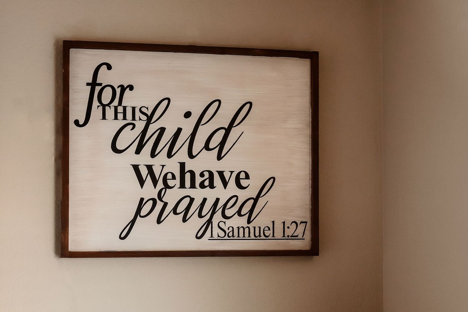 Rustic framed wood sign reading For This Child We Have Prayed Samuel 1:27 hung on nursery wall.