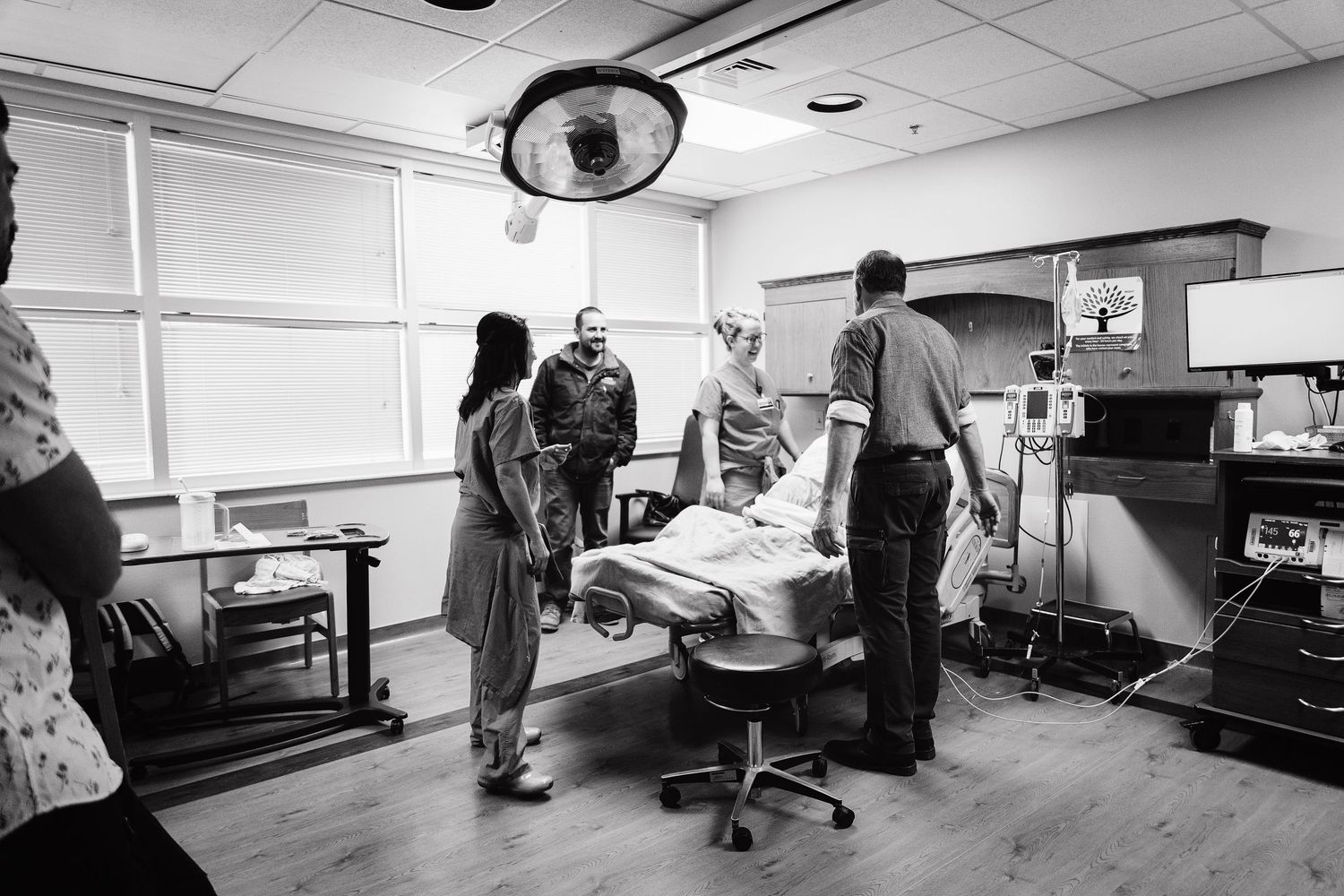 Medical team prepares patient in hospital labor and delivery room before birth.