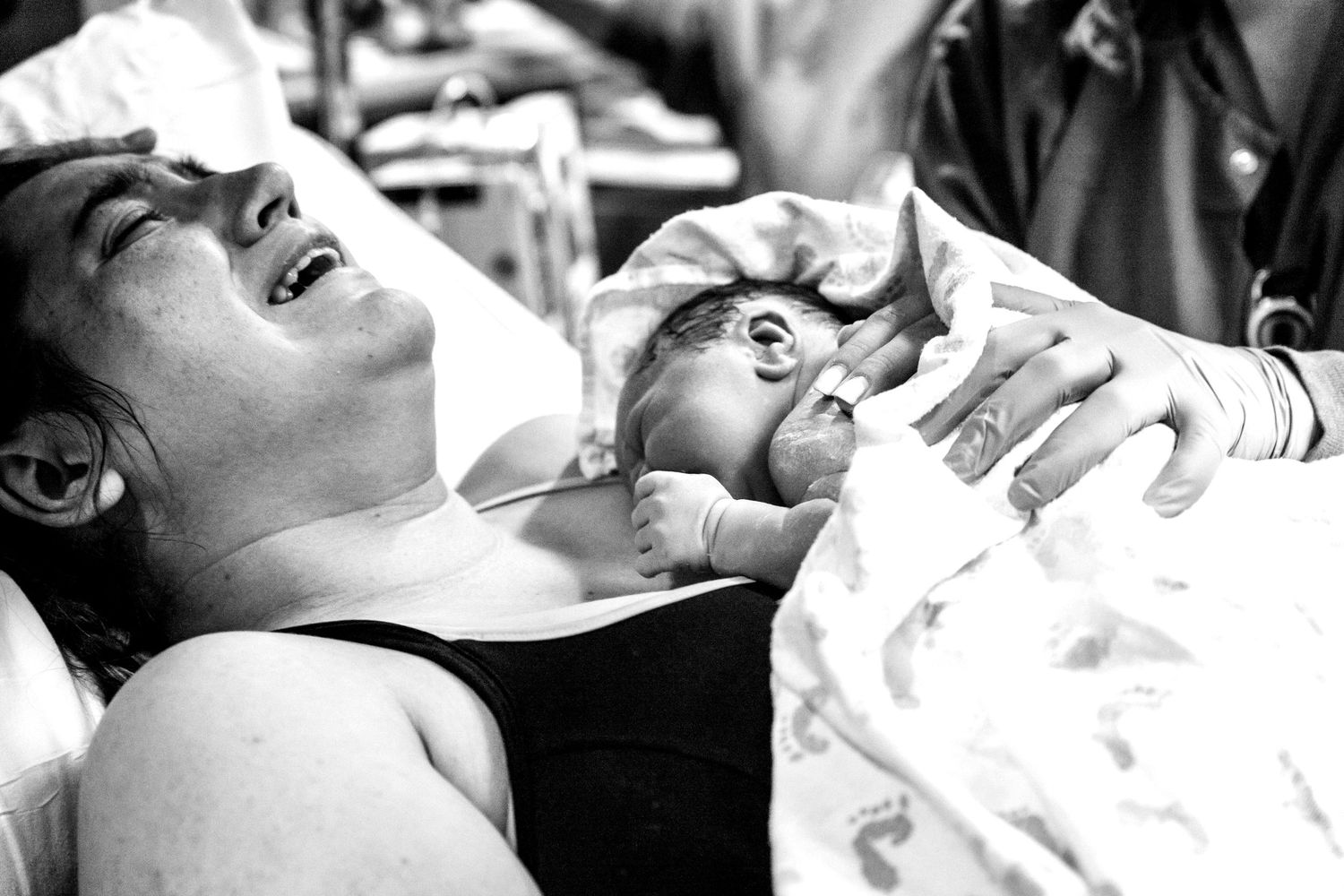 Mother experiencing joy holding her newborn baby for the first time after delivery.