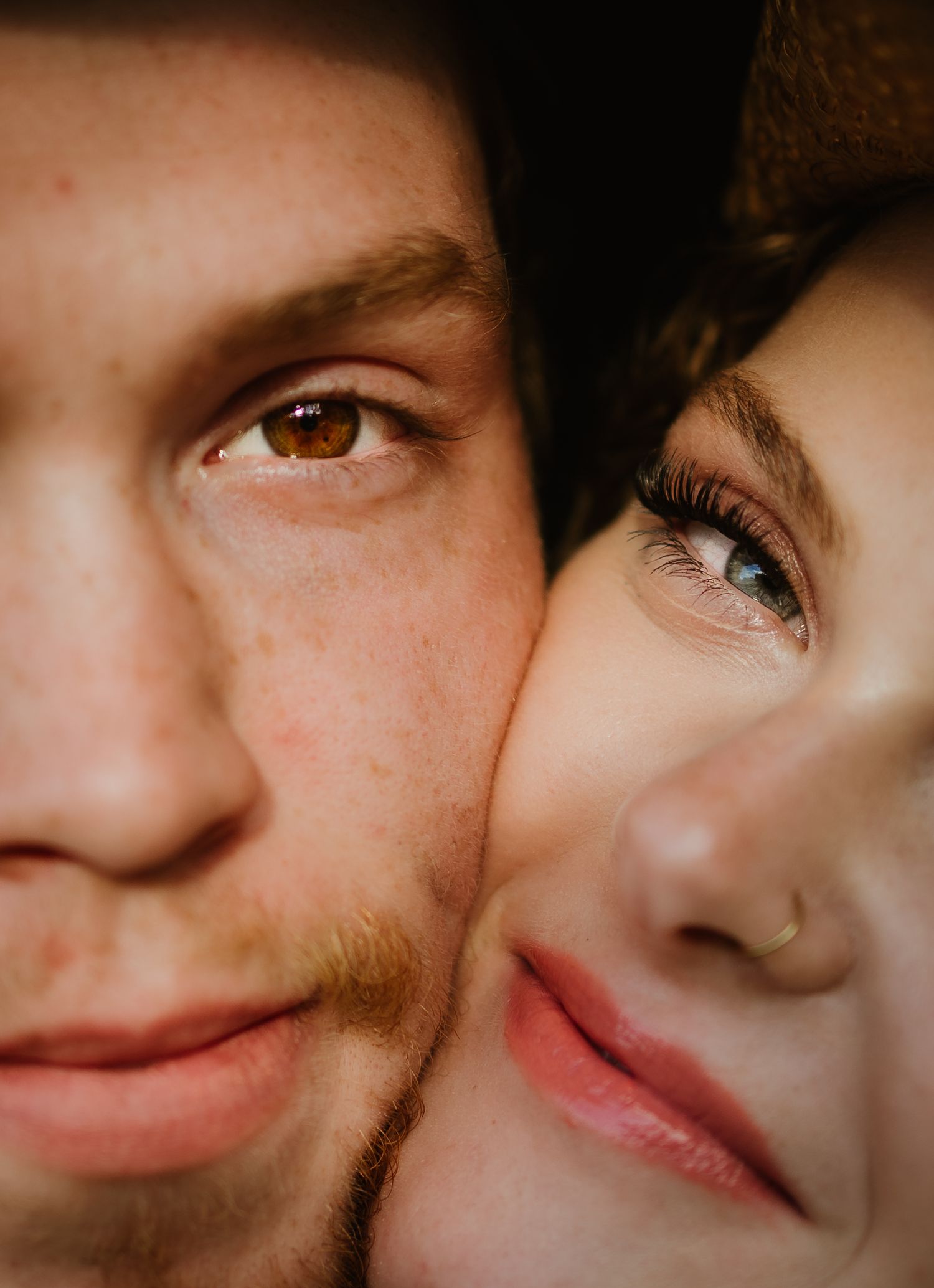Intimate close-up portrait of a couple with their faces together, showing detailed features.