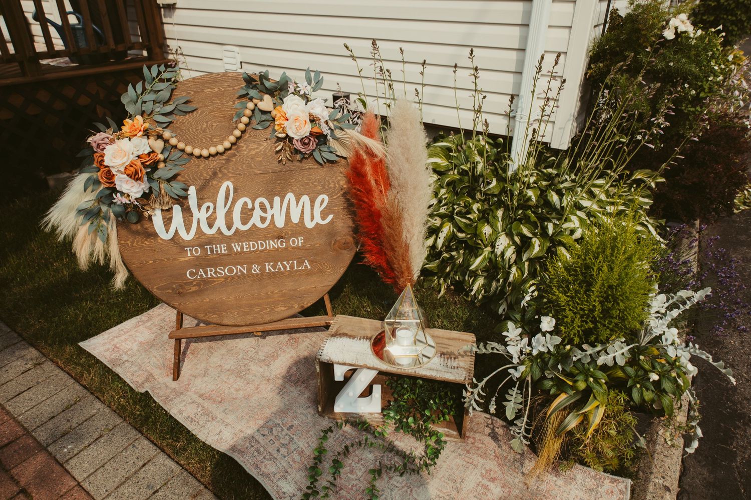 Round wooden Welcome wedding sign for Carson and Rayla with boho floral decor.
