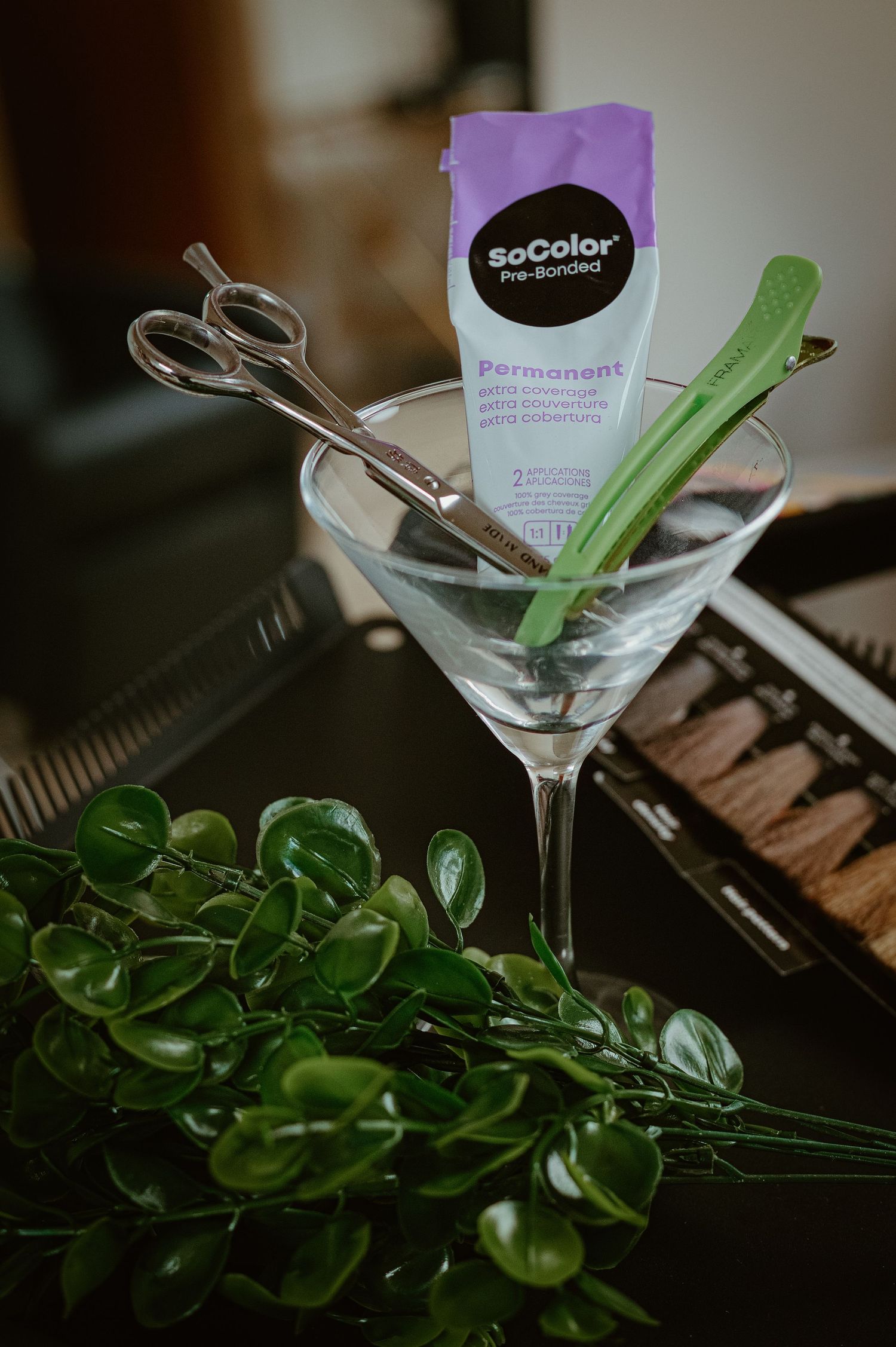 SoColor Pre-Bonded Permanent hair dye packet in a martini glass with scissors and green mixing brush.