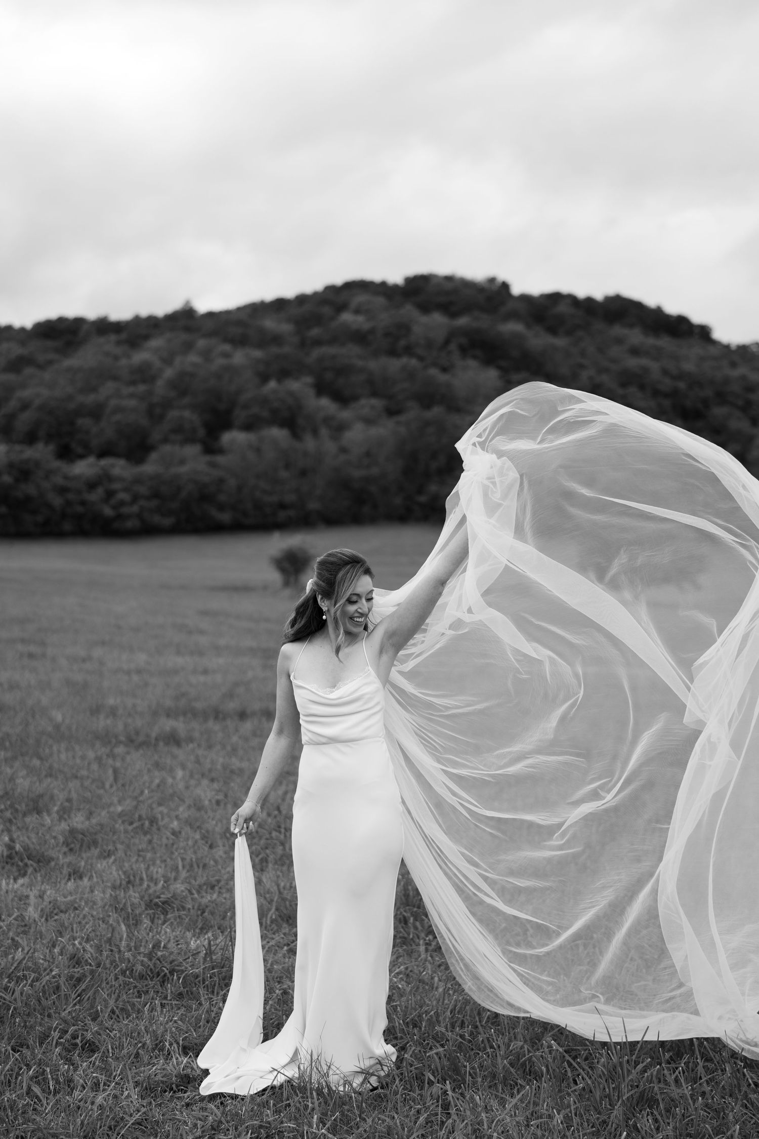 Dramatic black and white photo of billowing wedding veil against mountain landscape at battle mountain farm in Nashville TN.