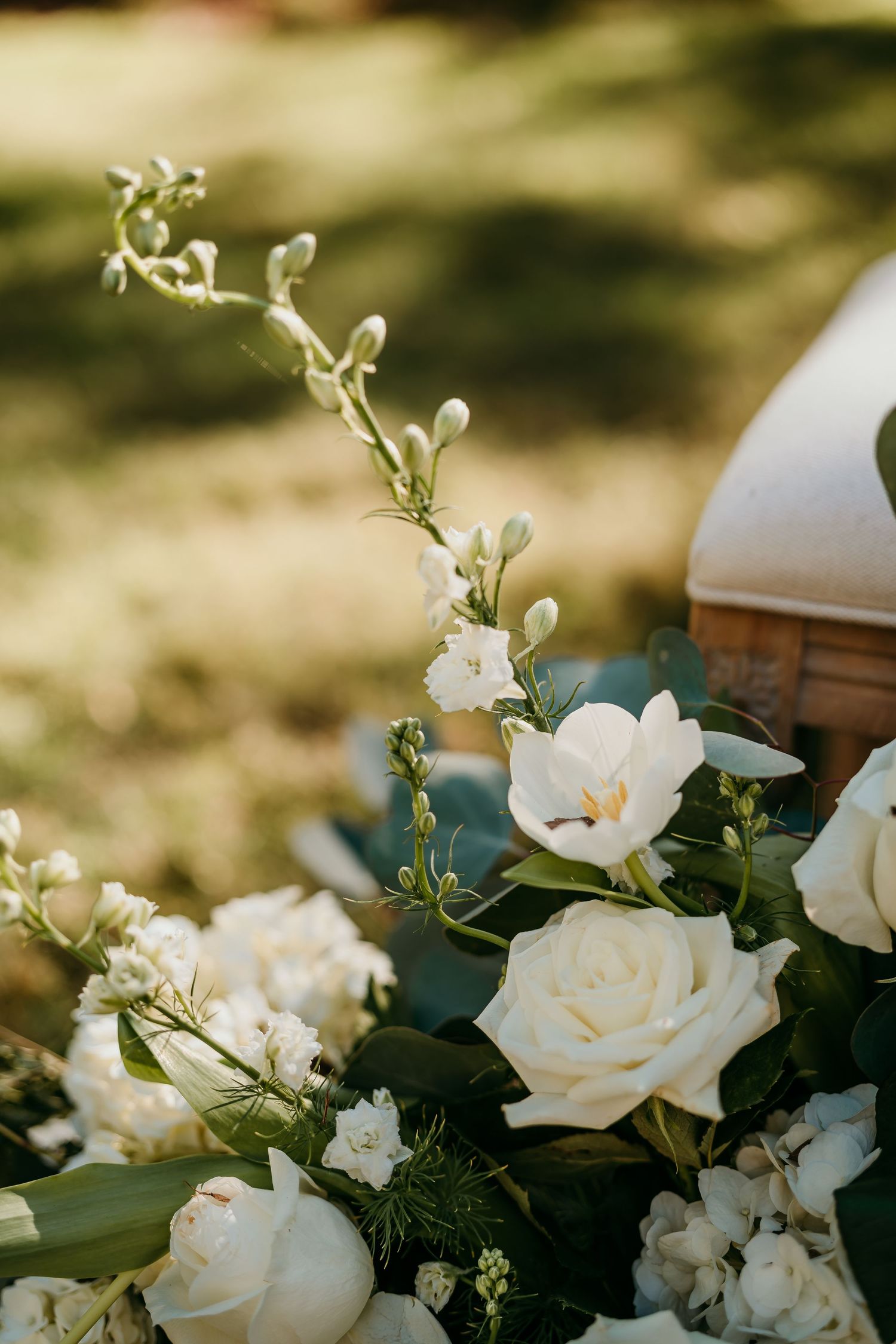 Close-up of an elegant white rose bouquet with delicate florals and green foliage in soft natural lighting in Nashville TN