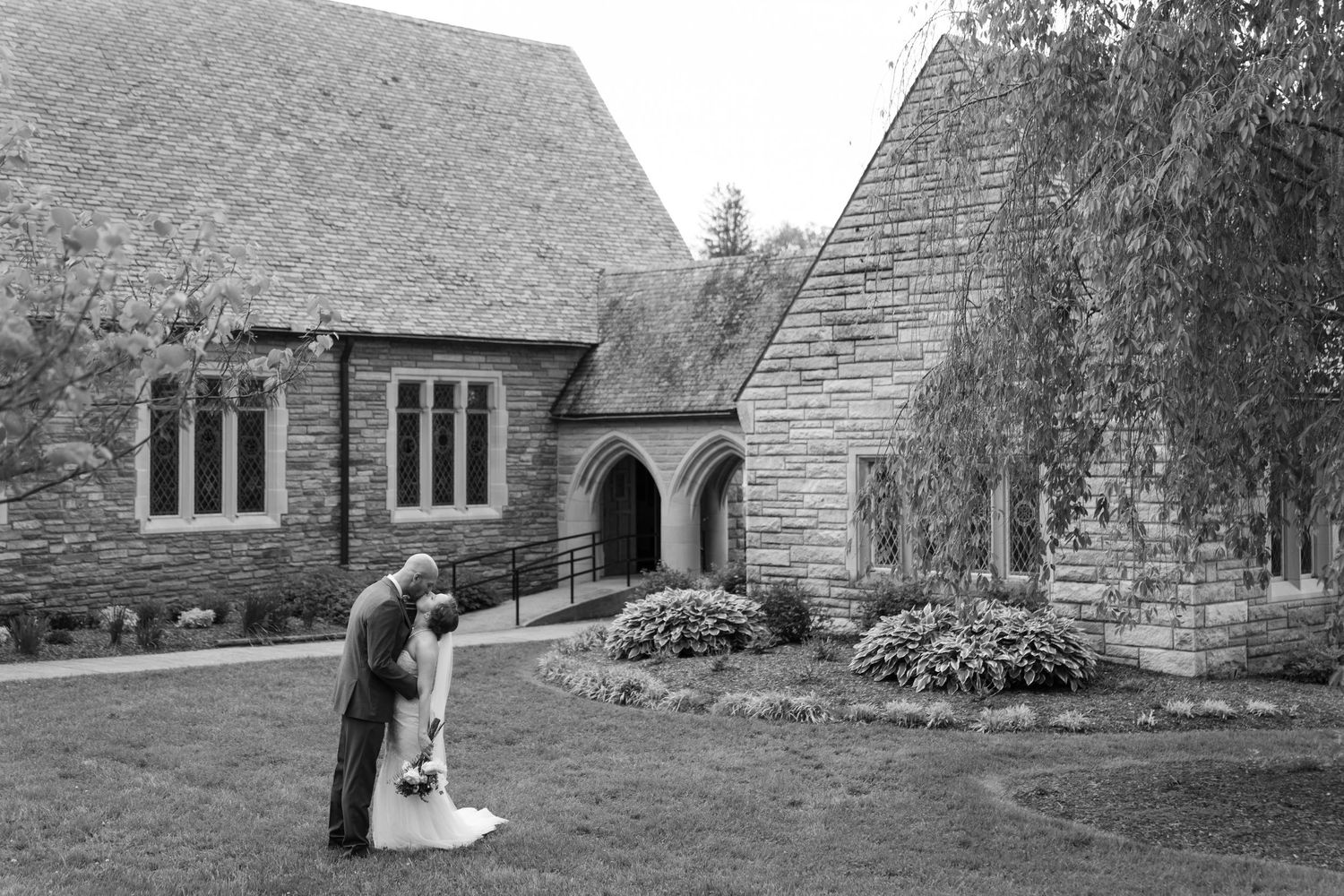 A stone church exterior provides a classic backdrop for a wedding celebration.