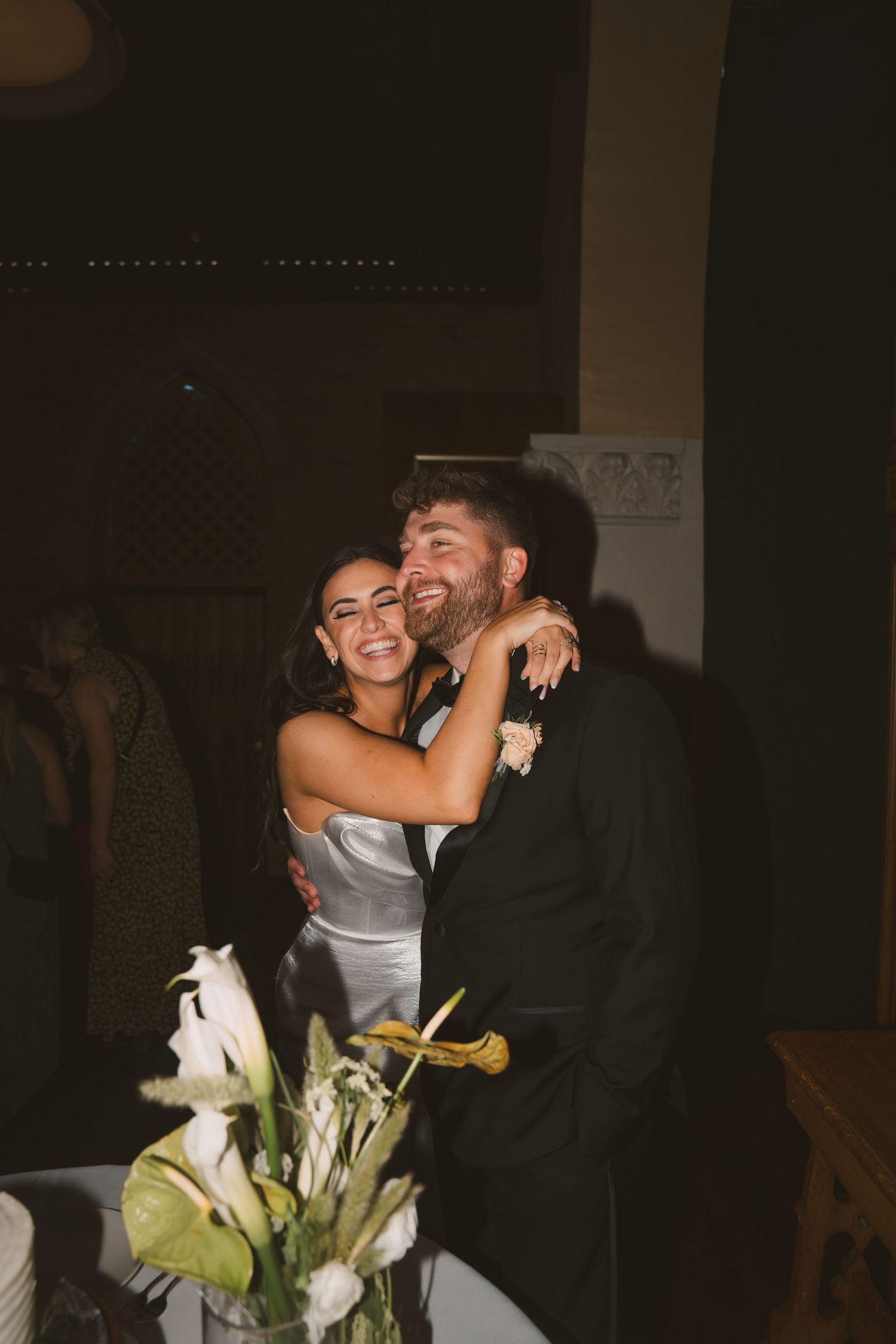 A candid moment of celebration and laughter during a wedding reception.