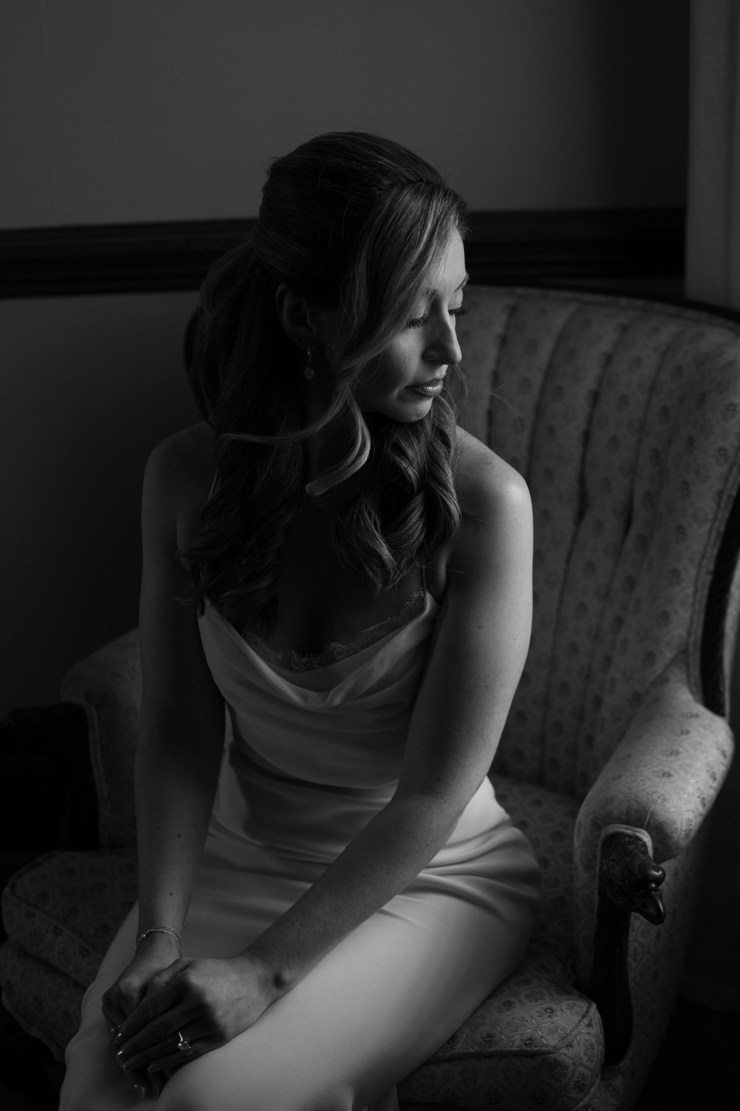 Artistic black and white portrait of a woman in evening wear sitting on vintage furniture at battle mountain farm in Nashville TN.