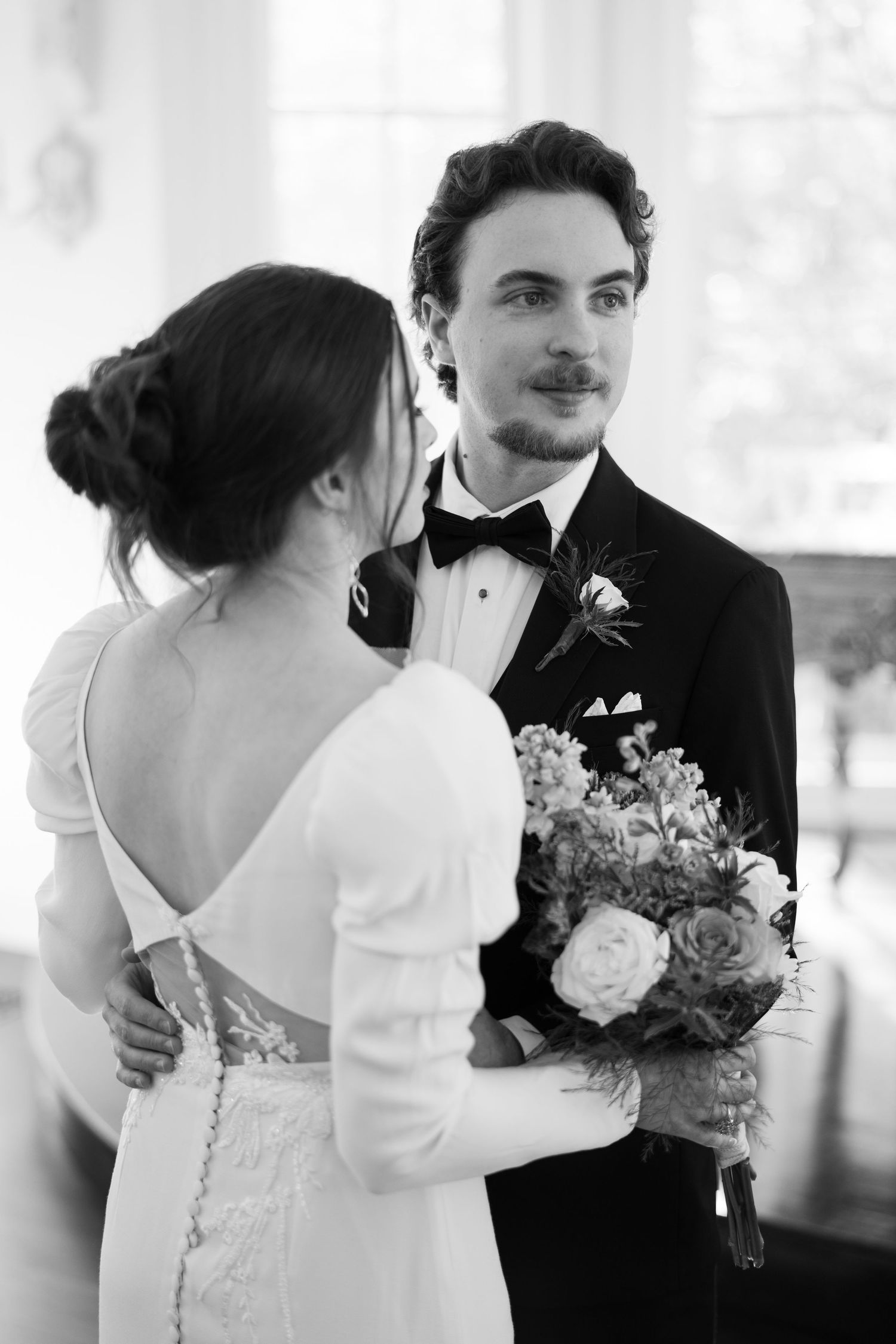A romantic black and white wedding sequence shows a couple embracing in formal attire during their special moment.