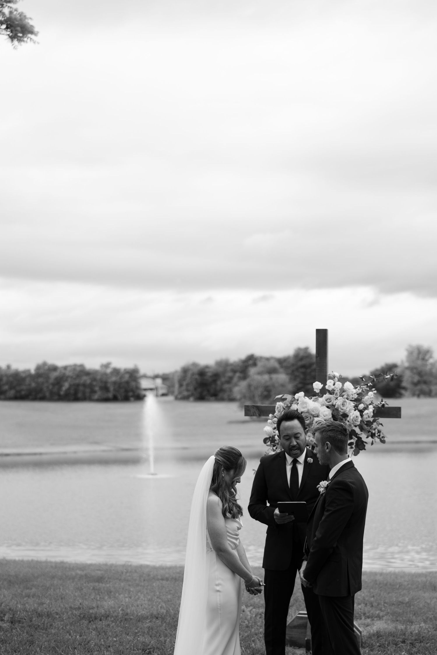 An outdoor lakeside wedding ceremony with floral cross backdrop at battle mountain farm in Nashville TN.