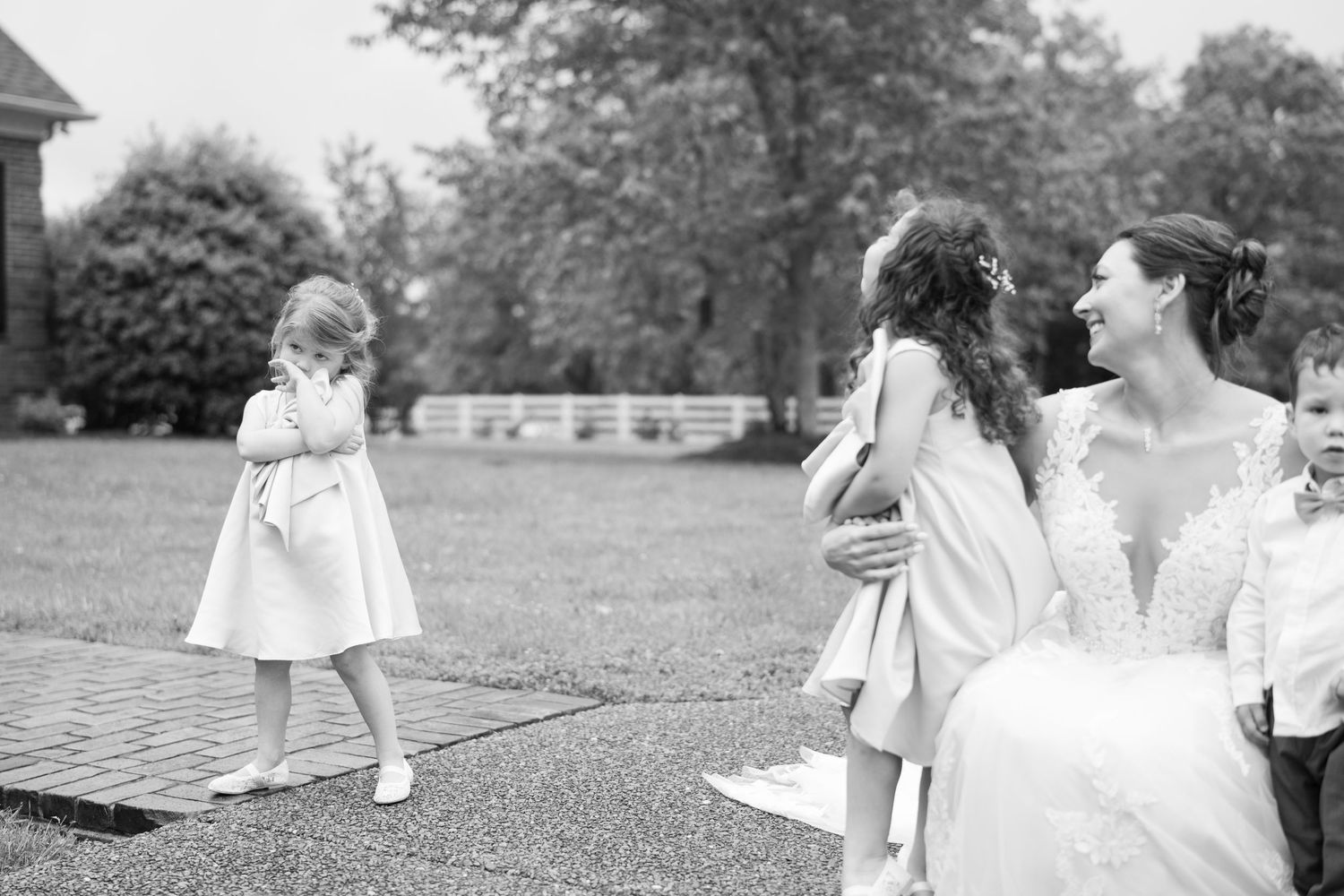Series of black and white photos showing children playing on grass during a wedding celebration.