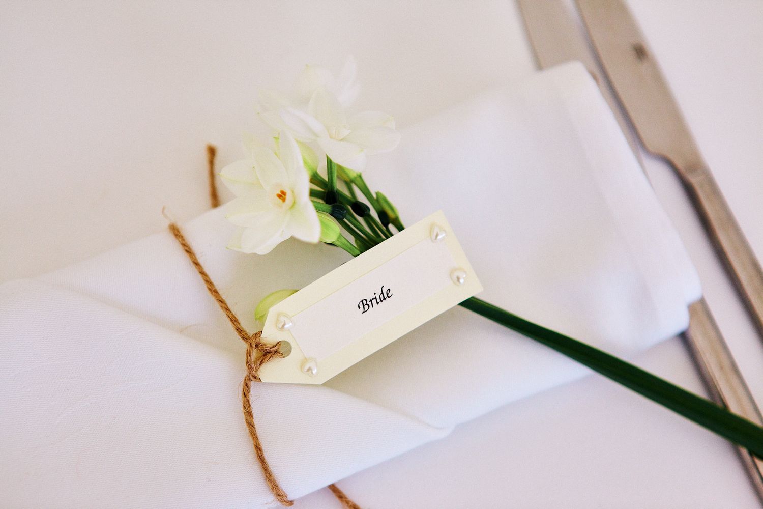Minimalist white place cards with delicate floral accents for wedding reception.