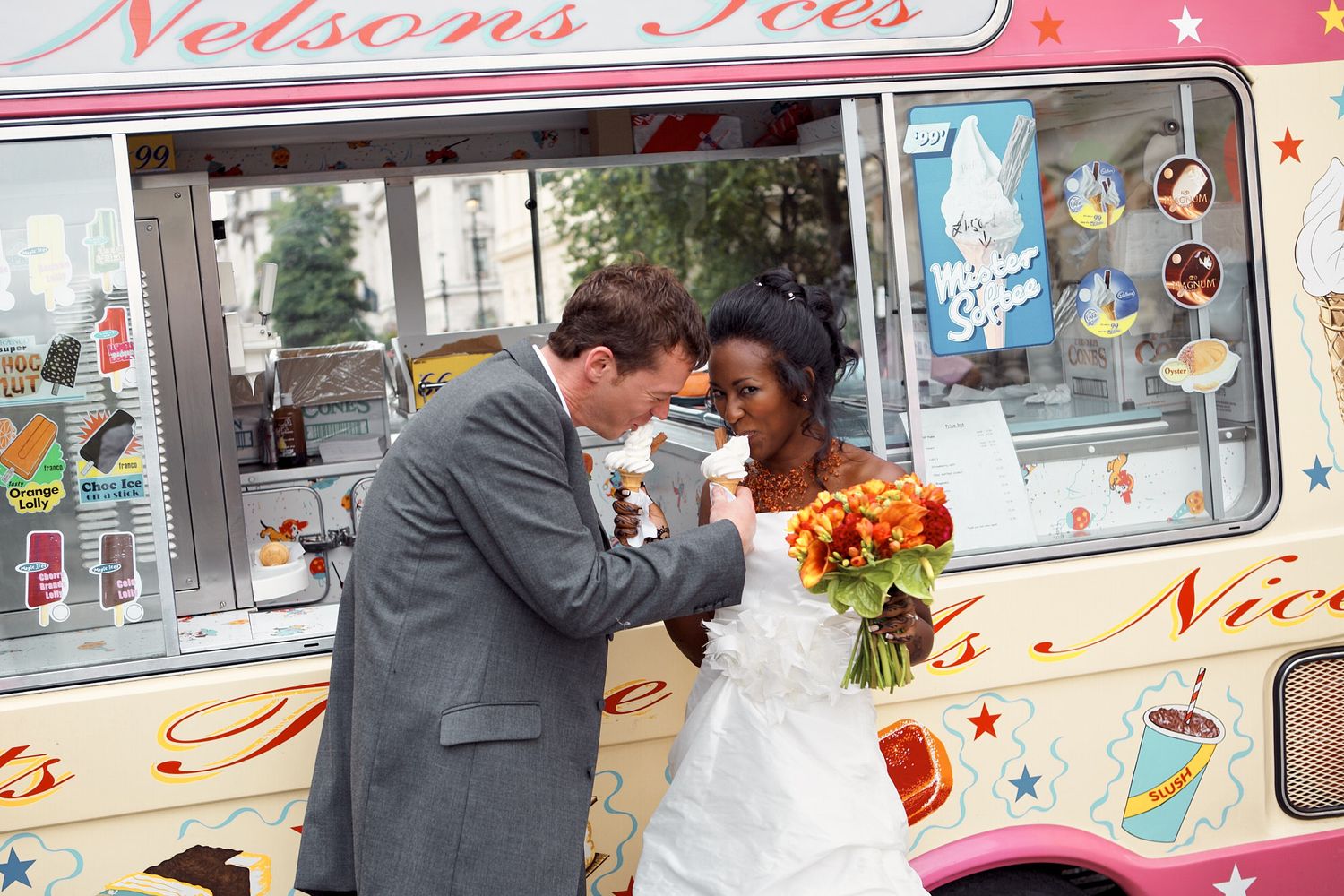 Wedding couple posing playfully by a vintage ice cream truck decorated with flowers, at a London hipster wedding.