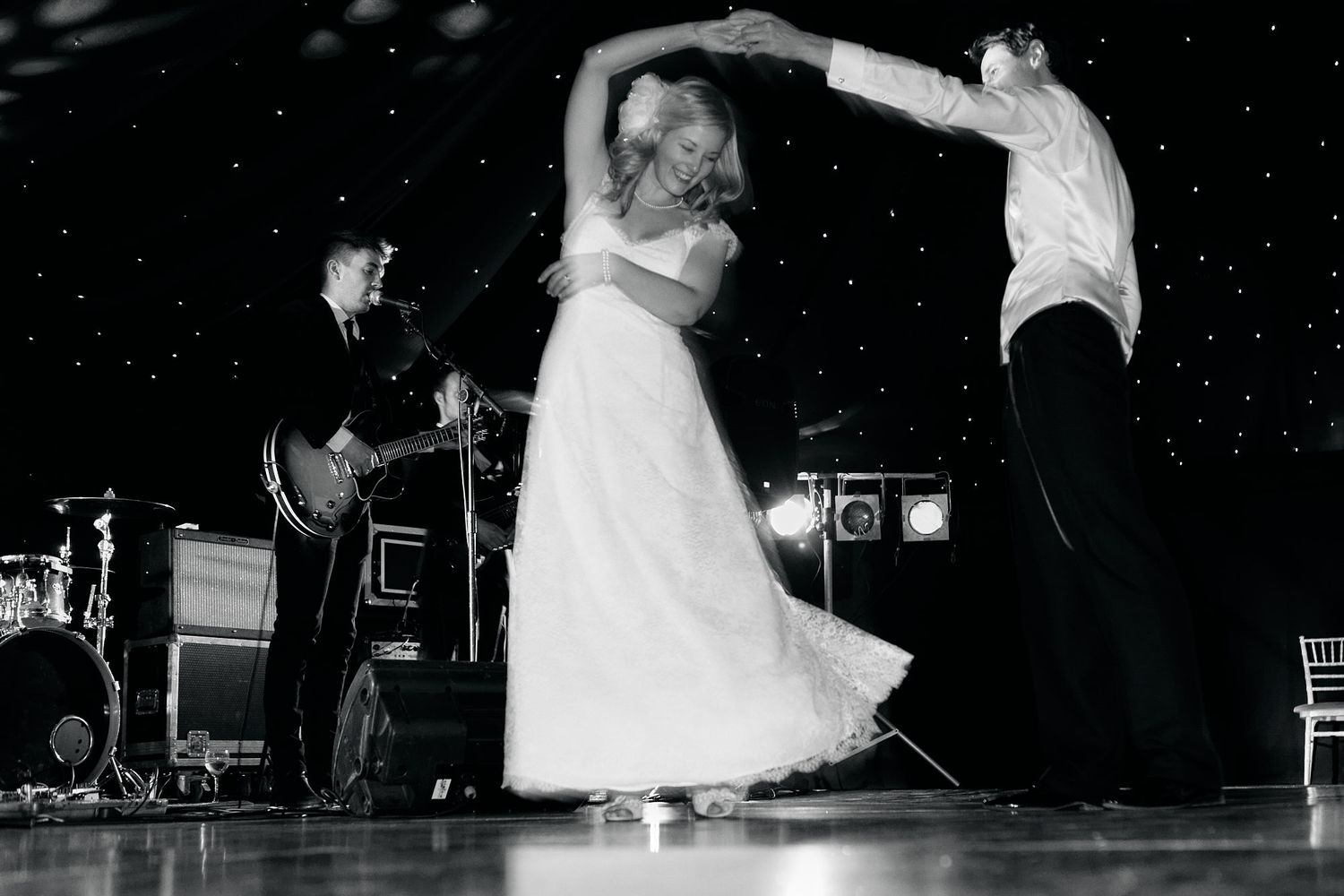 Black and white photo of couples dancing during evening wedding reception.