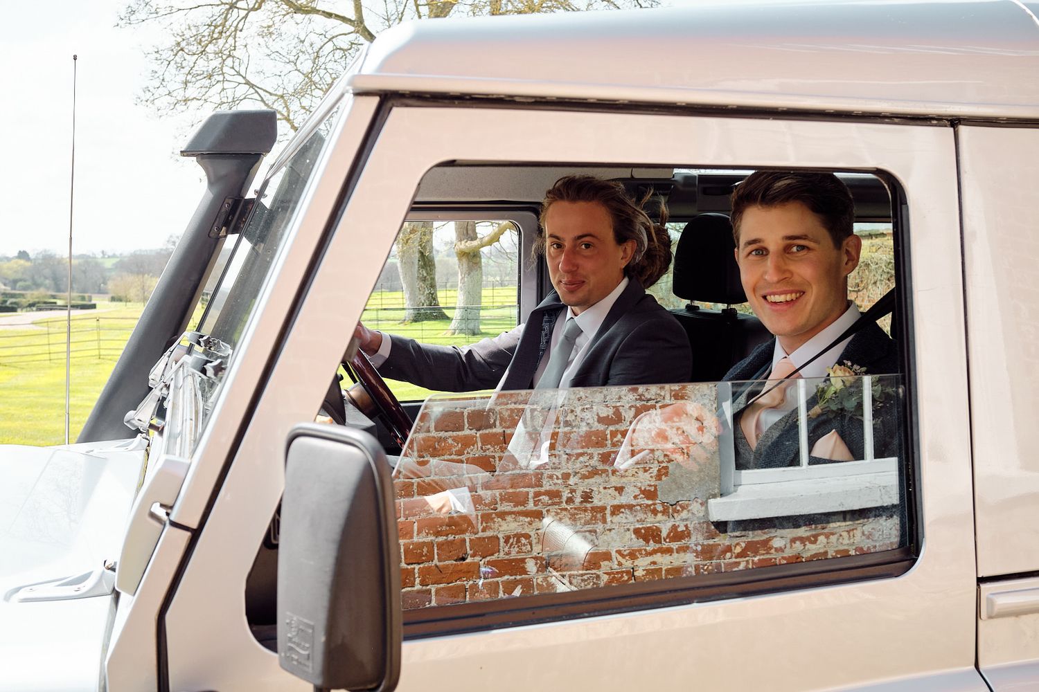 Wedding party members inside a vintage van smiling through the windows in Suffolk.