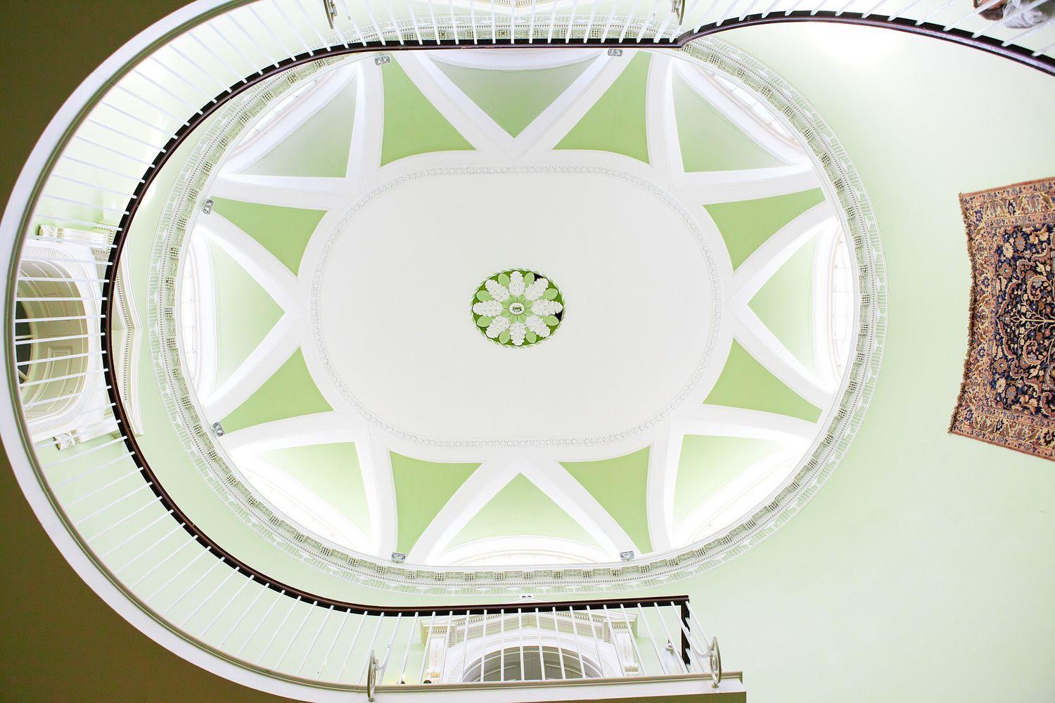 Decorative white and green geometric ceiling pattern design in classic architecture.