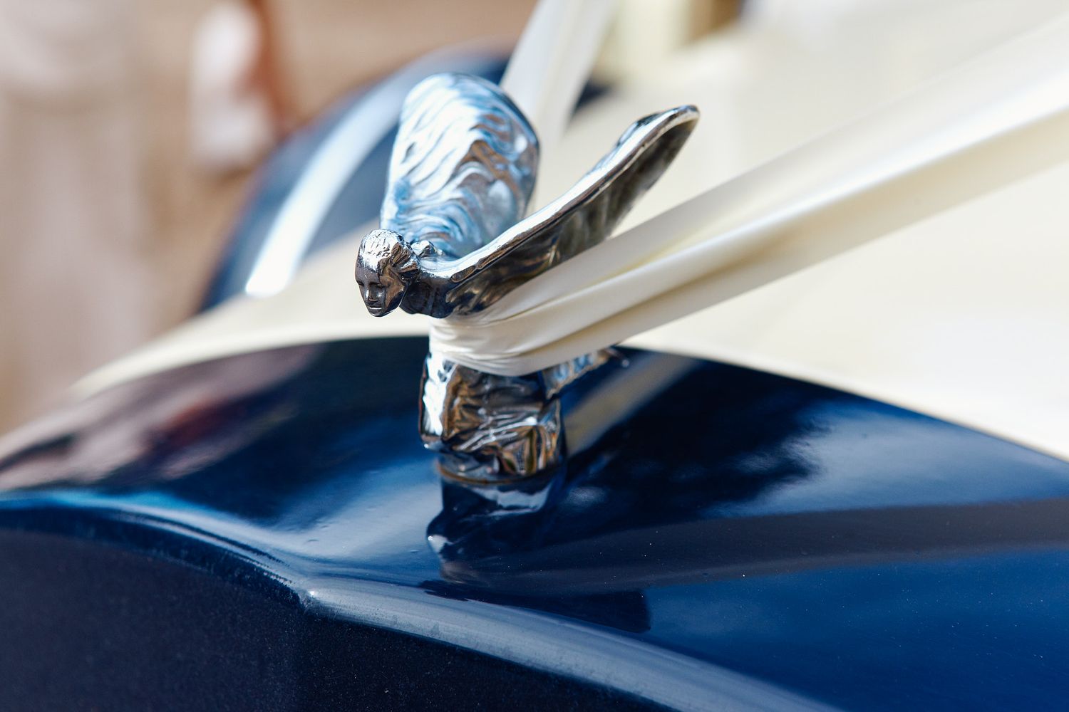 Vintage chrome hood ornament detail on classic car showing elegant flying design element at wedding near Brighton.