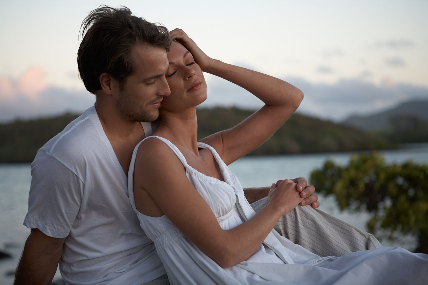 Intimate couple moment captured against scenic coastal landscape at dusk in Mauritius on destination wedding.