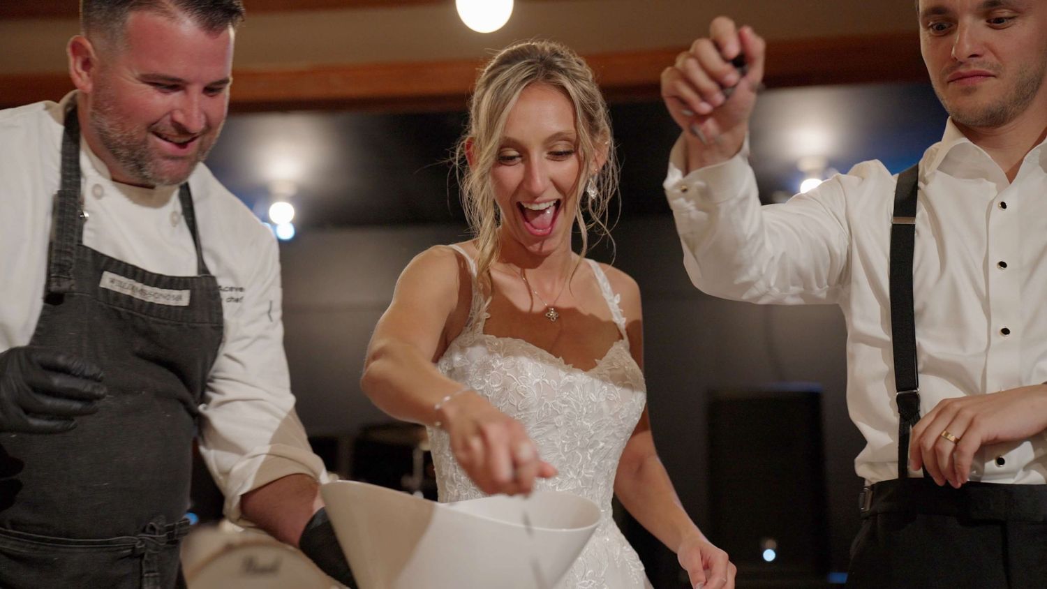 Bride and groom laughing while making their wedding cake live with Chef  Anthony Mario at Arrow Park reception.