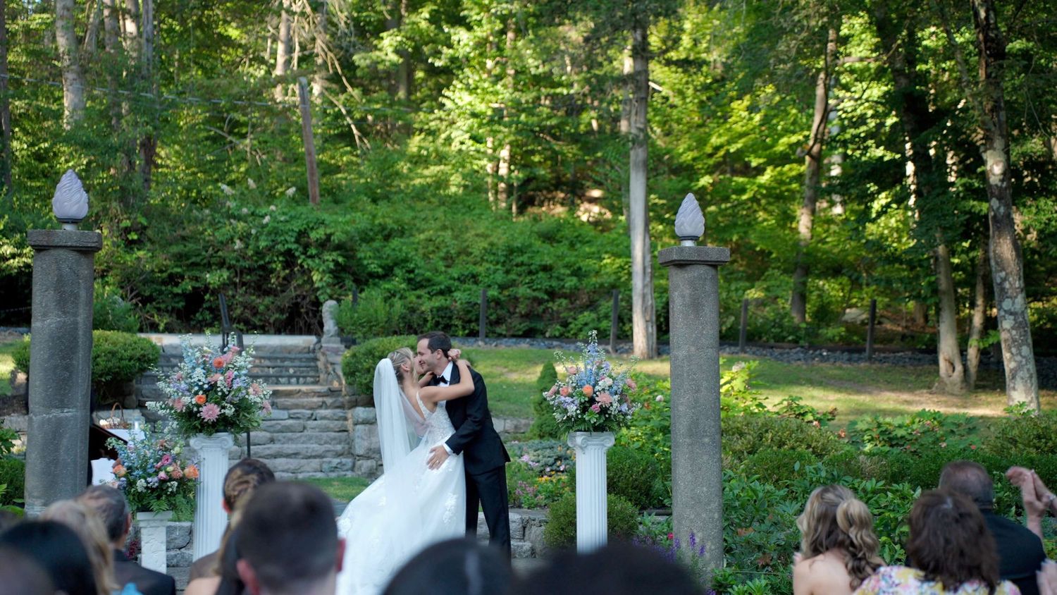 Couple's first kiss during outdoor Arrow Park wedding ceremony 2