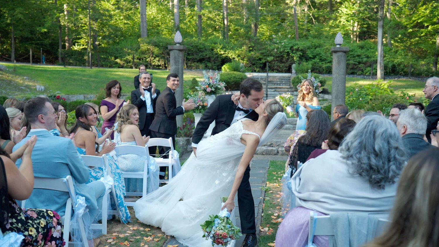 Couple's first kiss during outdoor Arrow Park wedding ceremony.
