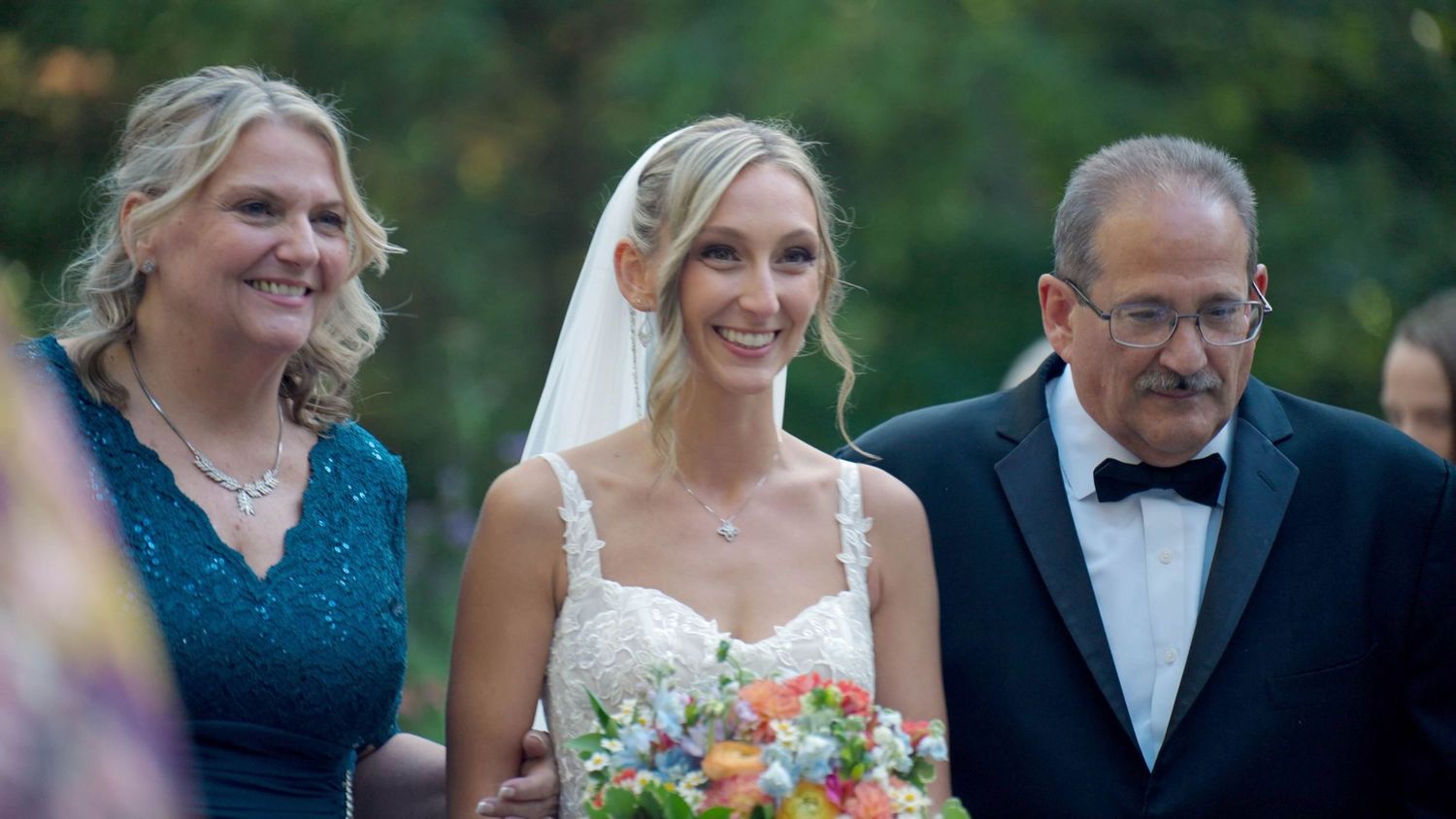 Bride walking down aisle during outdoor Arrow Park wedding ceremony.