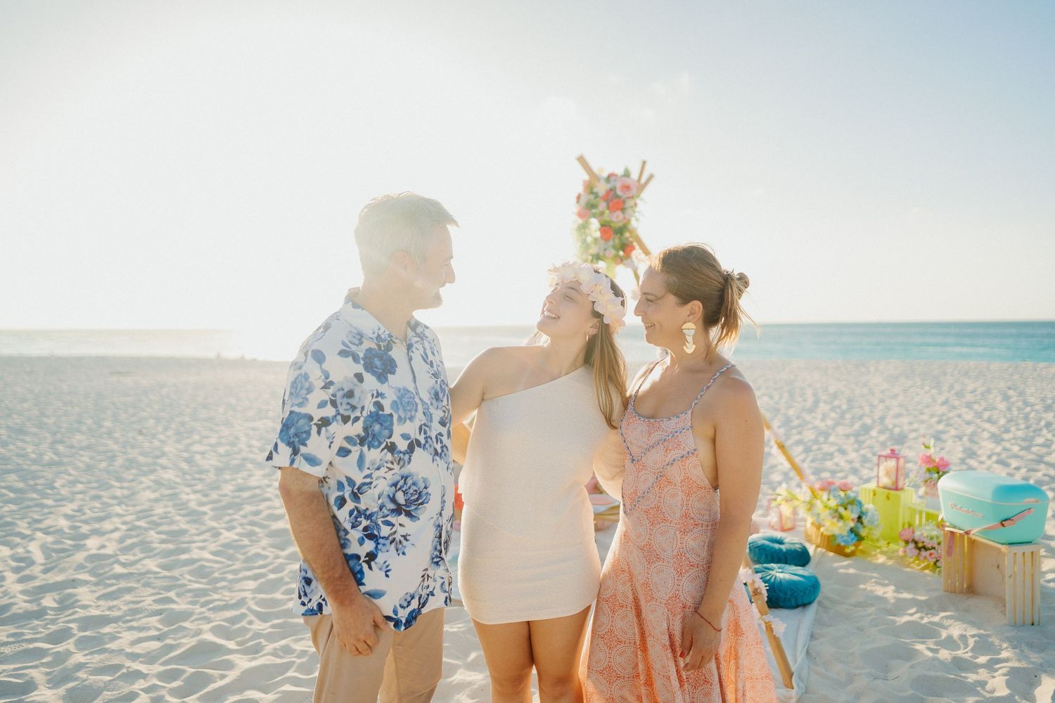 Group enjoying a sunny beach day with umbrellas and beach chairs along the sandy shoreline.