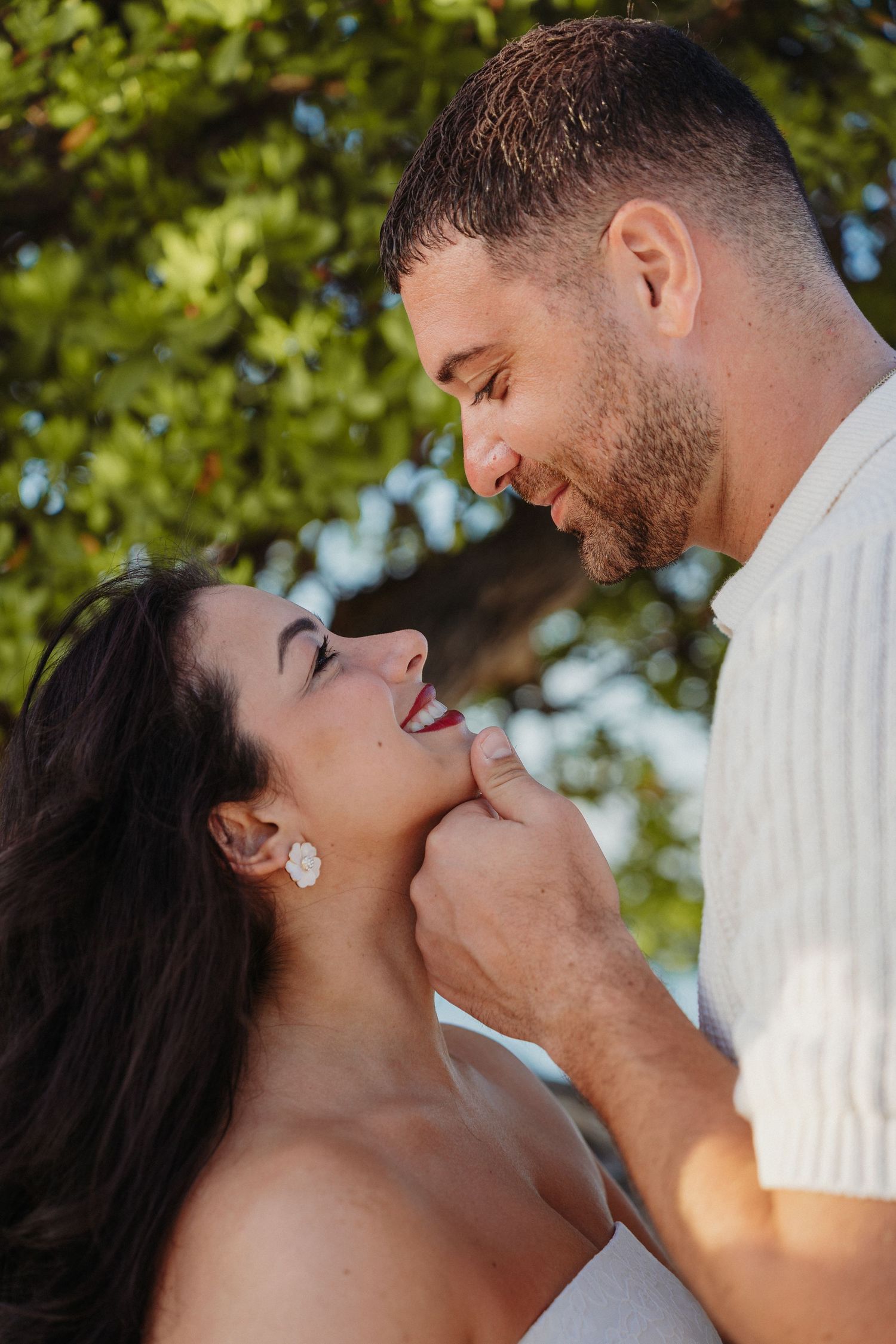 A romantic couple shares intimate moments in a series of outdoor photos with sunlit trees in the background.