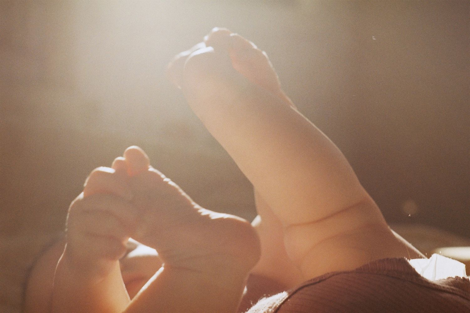 Soft sunlit close-up shots of hands and fabric creating an ethereal artistic composition.