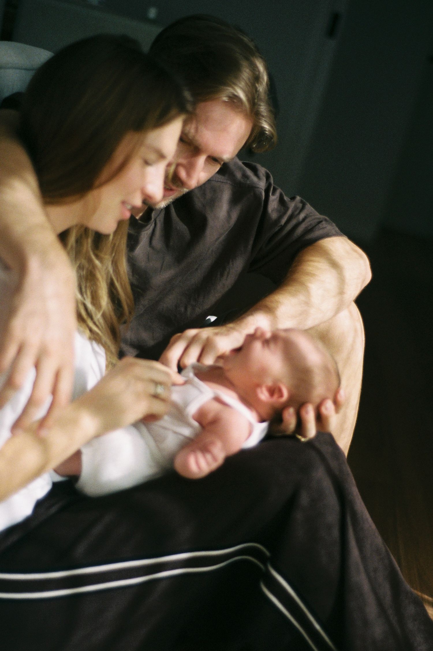 New parents lovingly gaze at their newborn baby, sharing a tender family moment together.