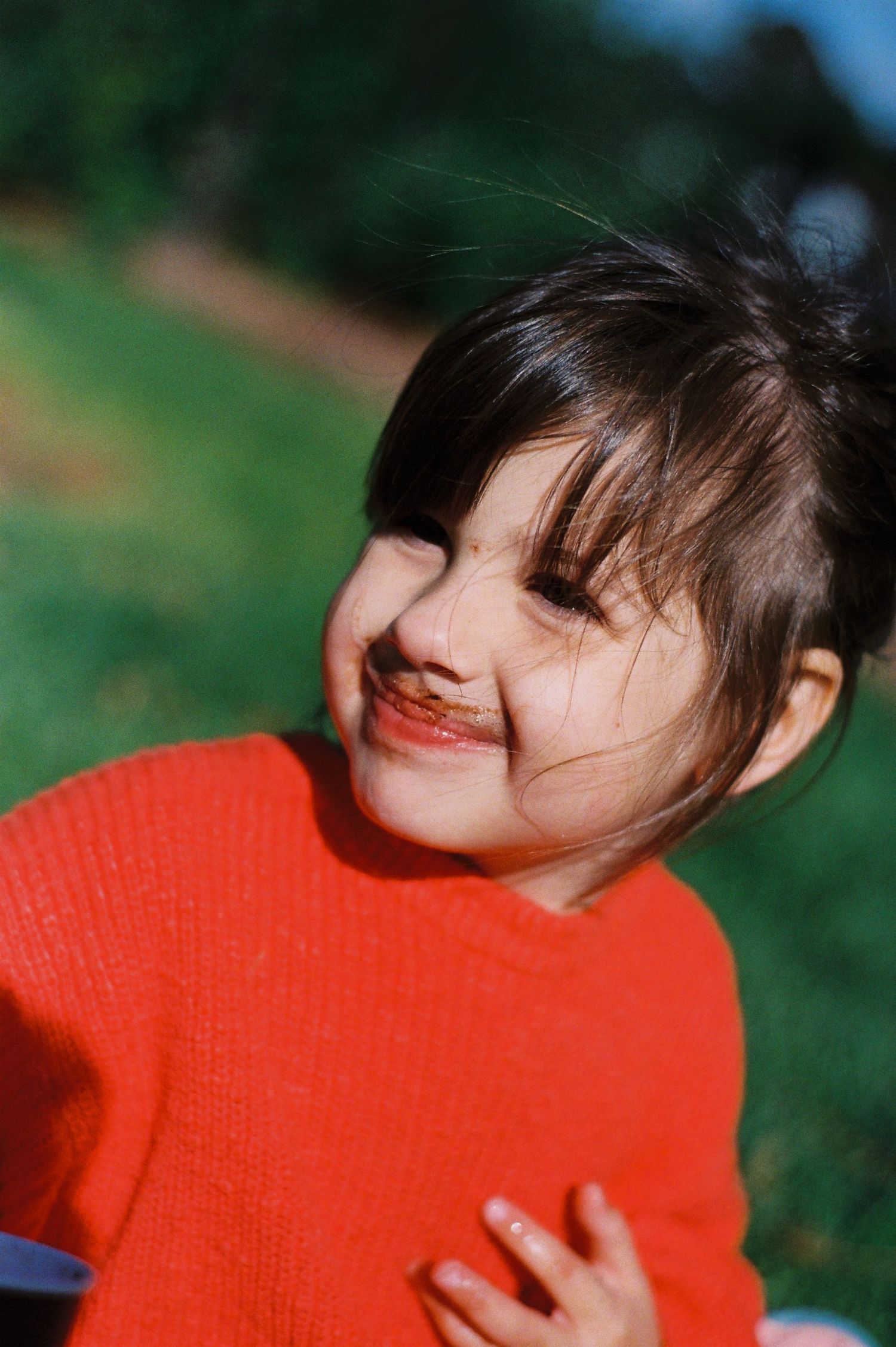 A sequence of photos shows a person in a bright red sweater smiling and laughing outdoors.