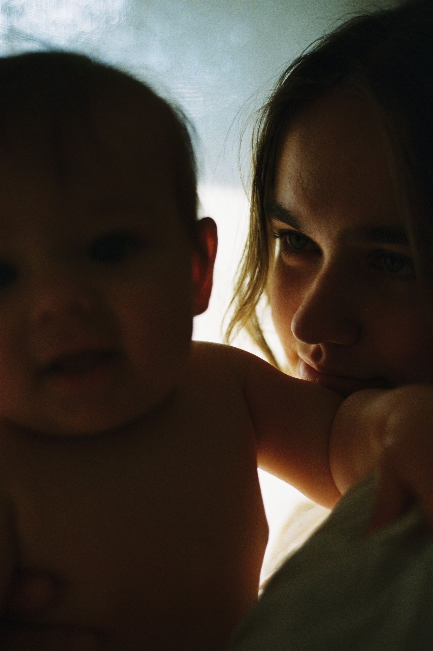 A series of silhouetted close-up shots showing tender interaction between two figures against a bright background.