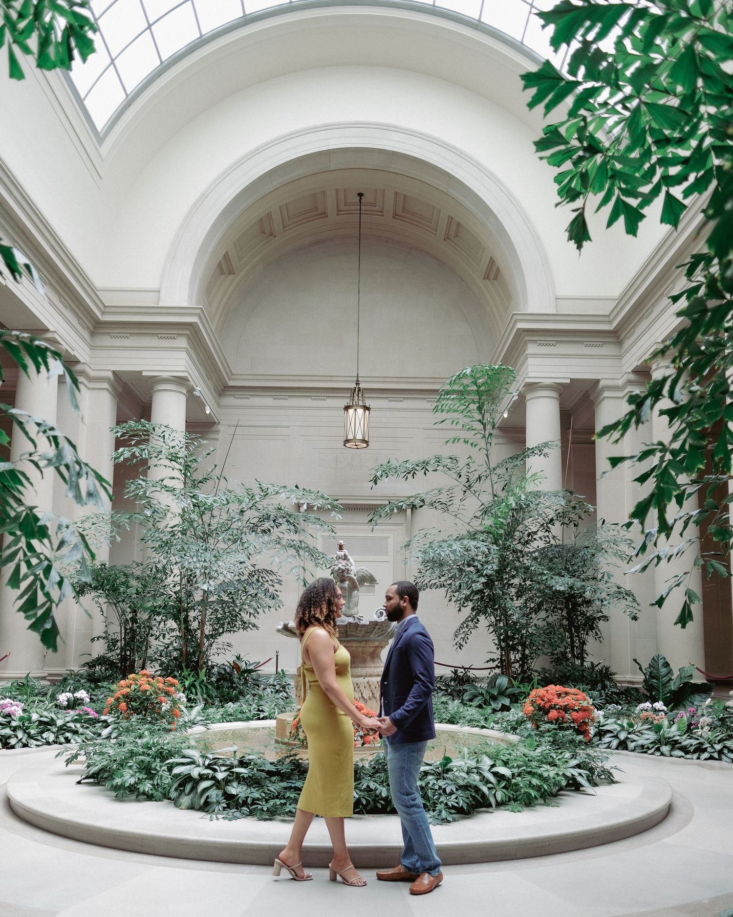 An elegant indoor garden space with arched ceilings and lush greenery.