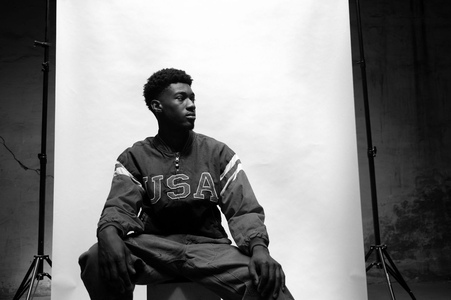 A dramatic black and white portrait against a bright background showing strong contrast.