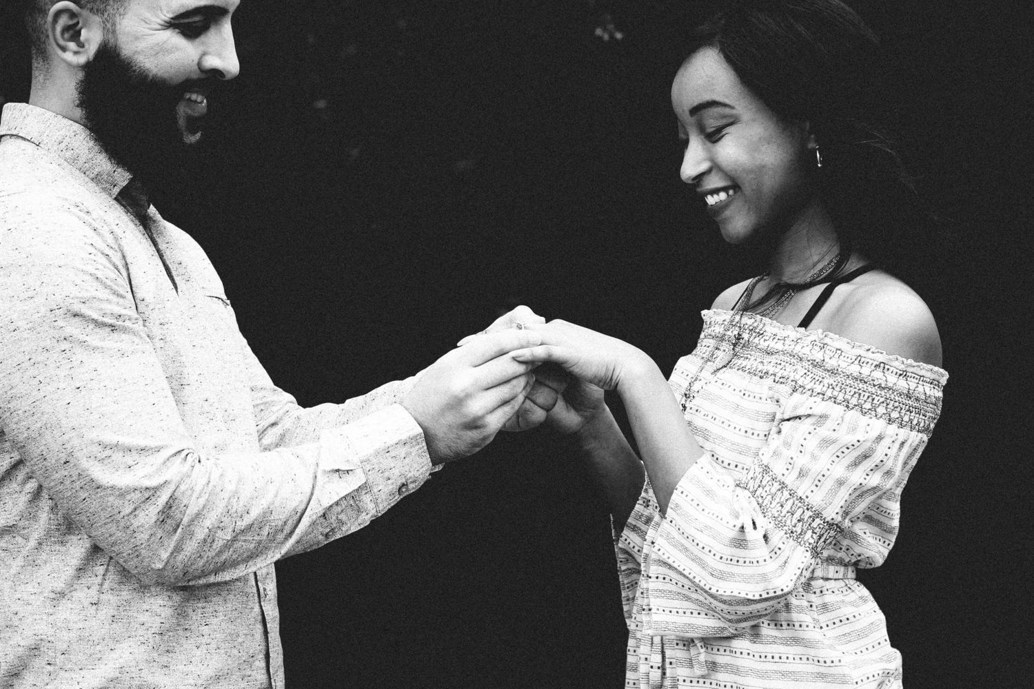 A black and white photo captures an intimate moment between a couple.
