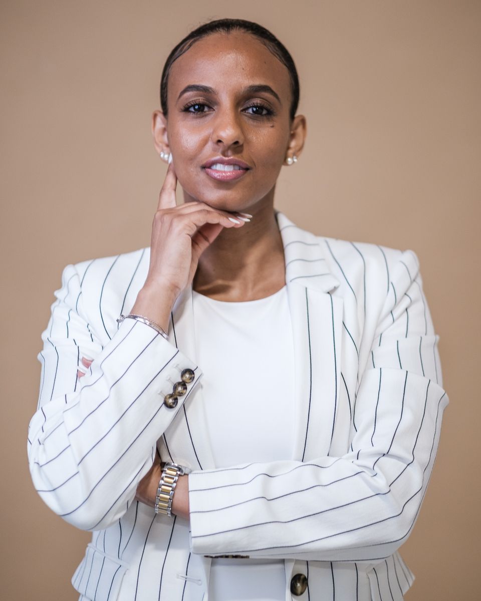 Professional studio portrait series showing different poses in a white pinstripe blazer against a neutral background.