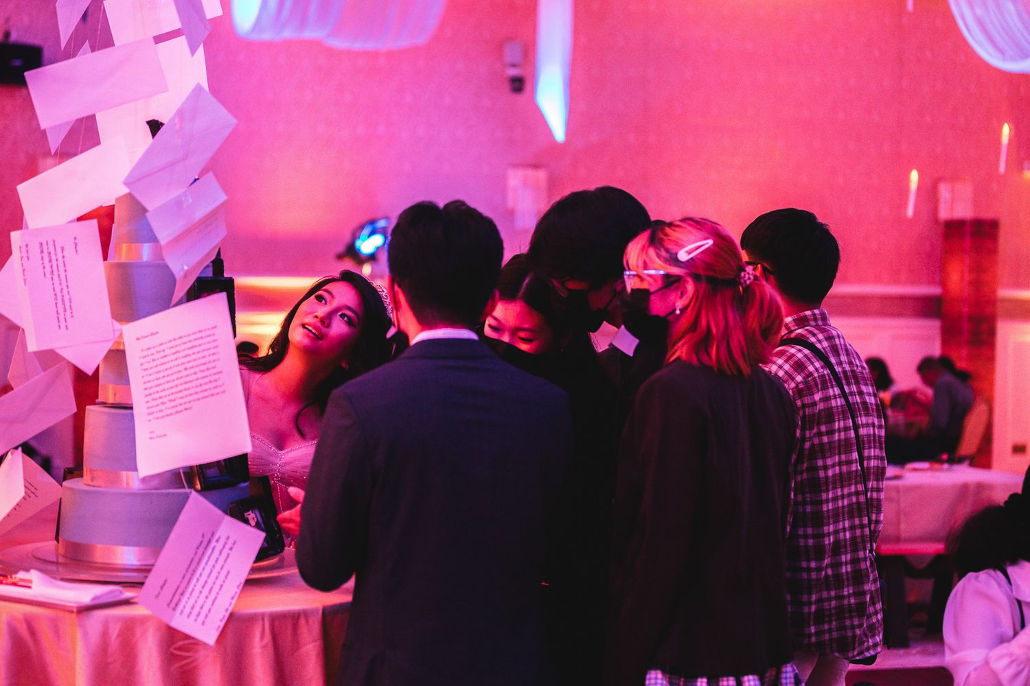 Guam event photographer capturing guests gather around a photo booth station under pink lighting at an indoor event.
