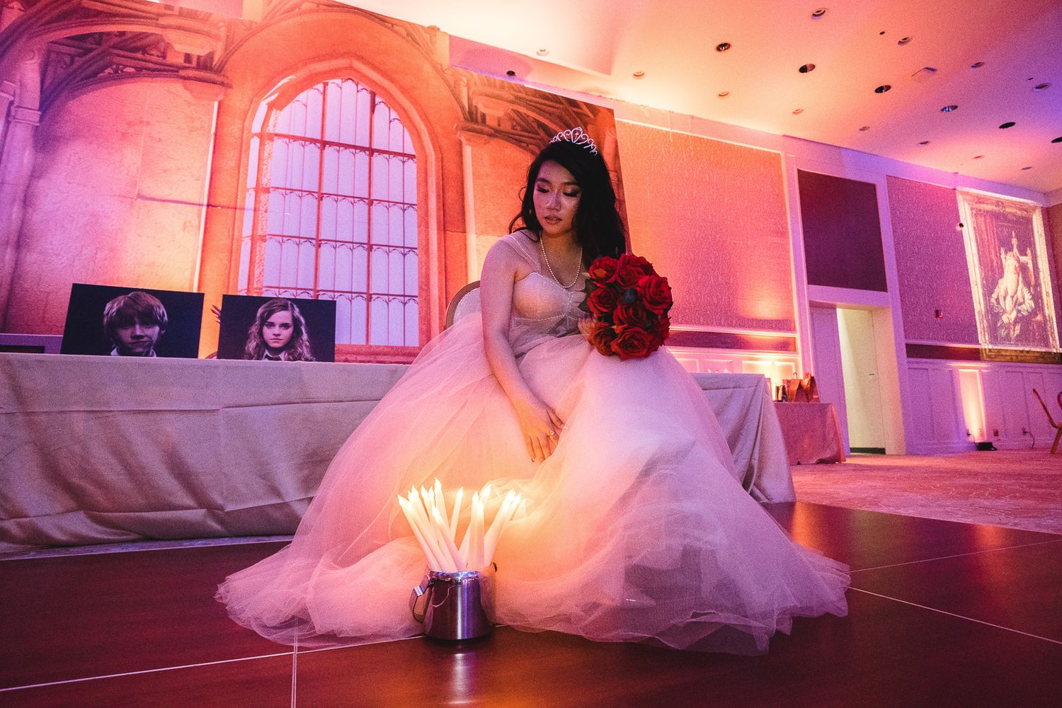 Guam event photographer capturing a young woman in a white ball gown holding red roses beside sparklers at a quinceañera celebration.