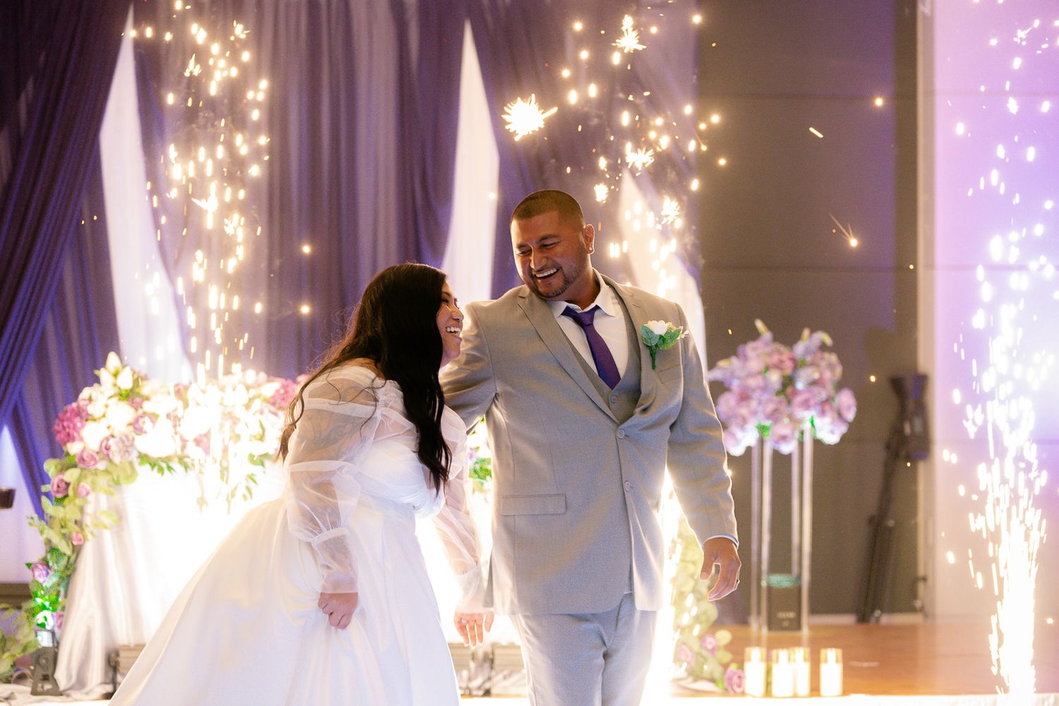 Guam wedding photographer capturing bride and groom share first dance surrounded by sparkling fireworks at elegant wedding reception venue.