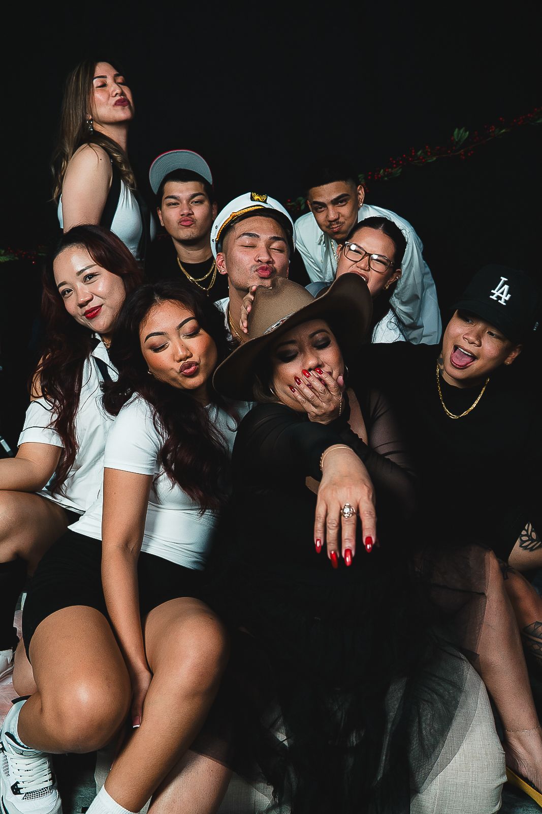 Guam event photographer capturing a group of young friends posing together and blowing kisses at a fun nighttime party.