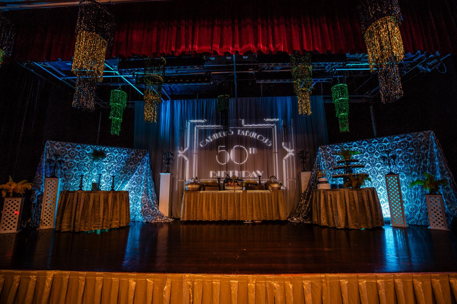 Guam event photographer capturing a decorated stage setup for a 50th birthday celebration with elegant gold and blue lighting.
