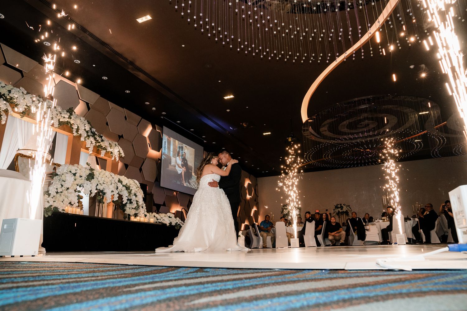 Guam wedding photographer capturing a couple sharing first dance surrounded by fountain sparklers in stunning ballroom wedding reception.