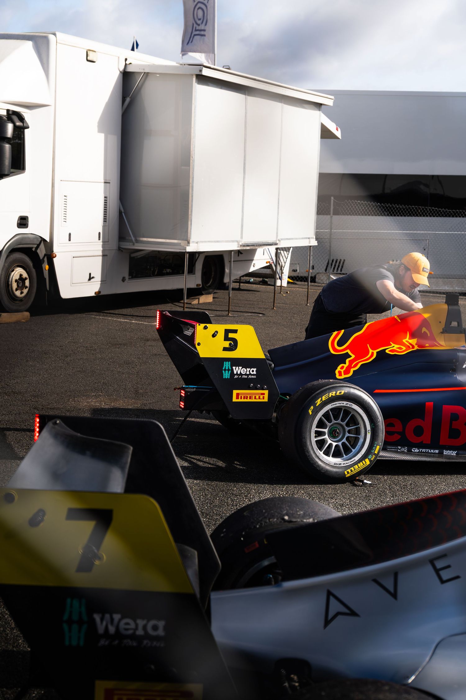 A Red Bull Racing Formula 3 car number 5 being pushed through a race paddock area.