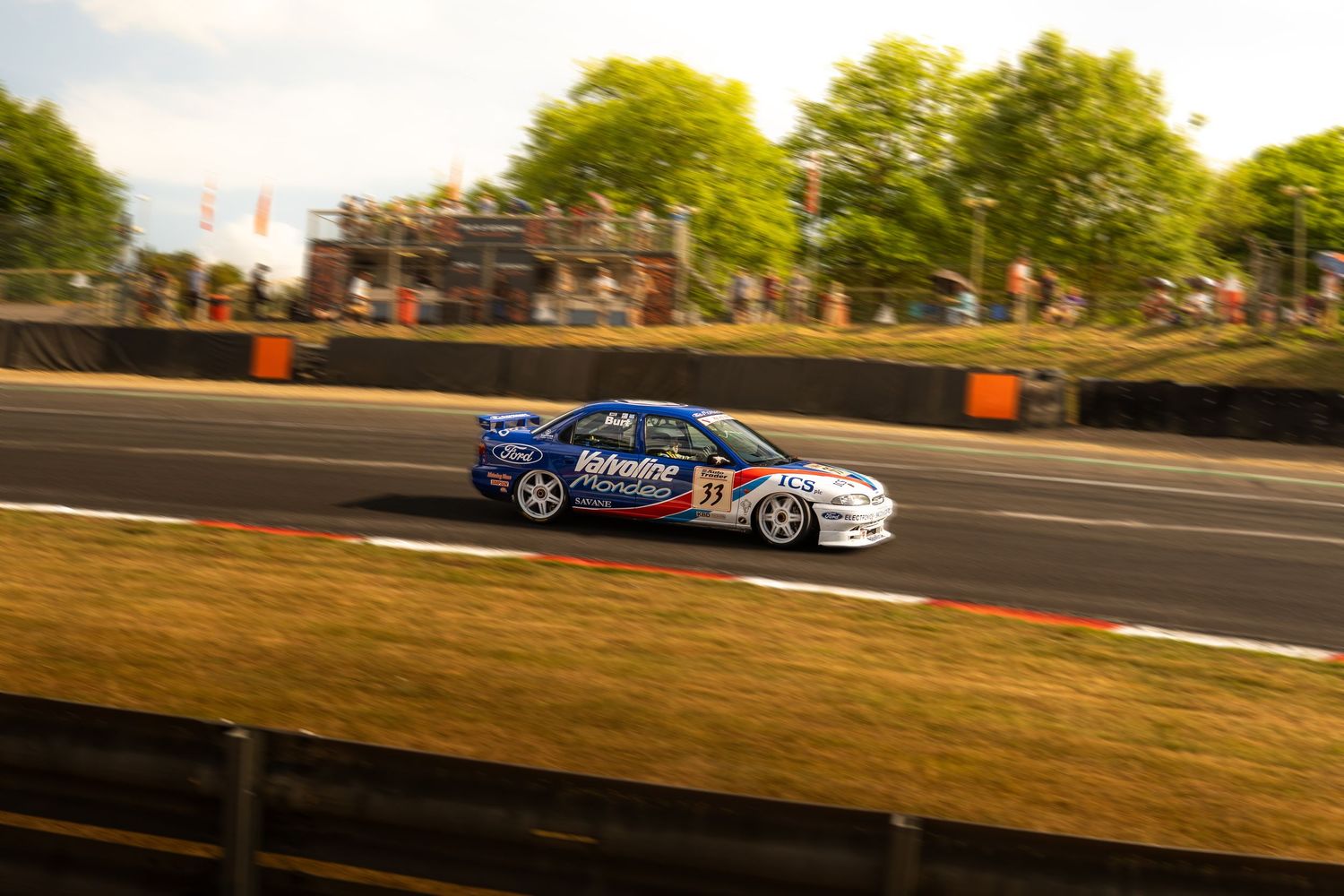 Blue Vauxhall Vectra touring car number 17 racing at speed on a sunlit motorsport circuit.