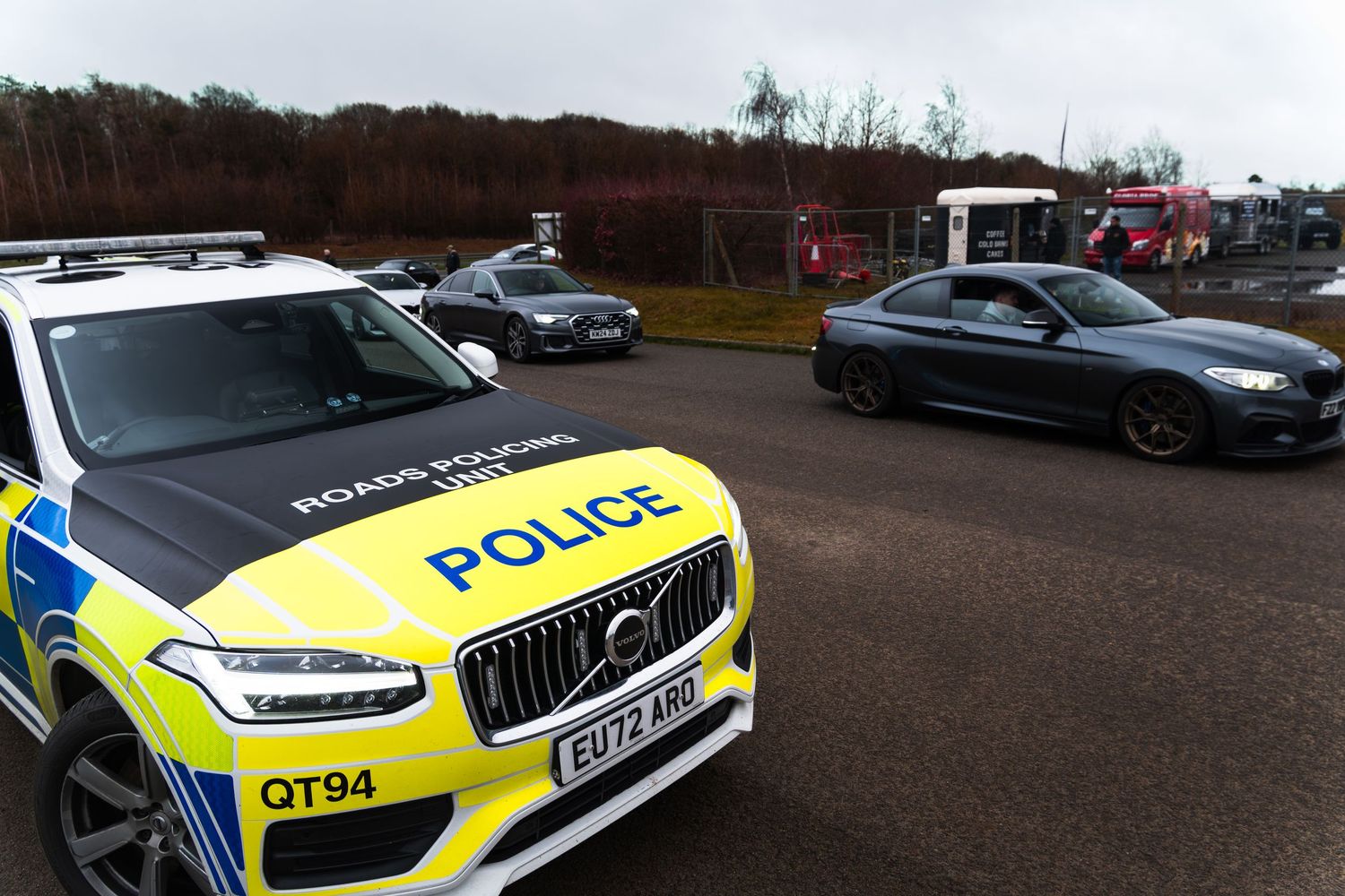 UK Roads Policing Volvo XC90 police car monitors exotic cars including BMW M6 at track day event.