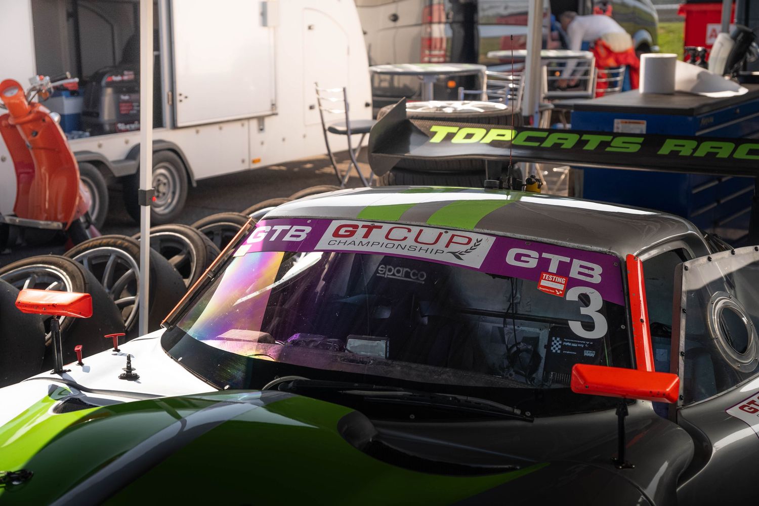 GT Cup racing car number 3 GTB class with colorful windscreen banner in pit lane.