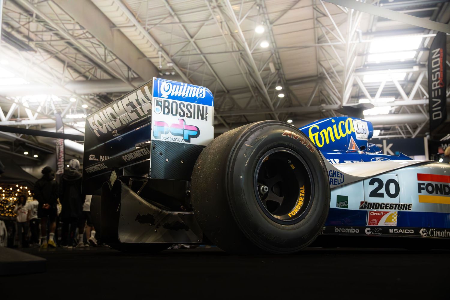 Blue and white Ligier Formula 1 car number 20 with Bossini sponsorship displayed at a motorsport event.