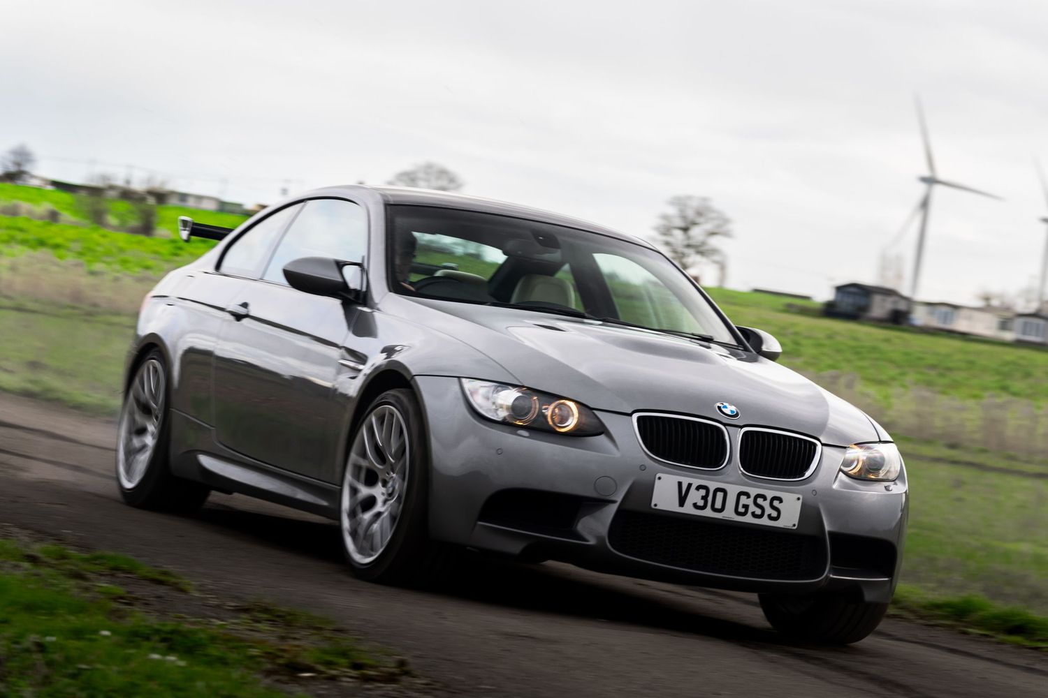 Silver BMW M3 E92 coupe with V30GSS plate cornering fast on a countryside road.