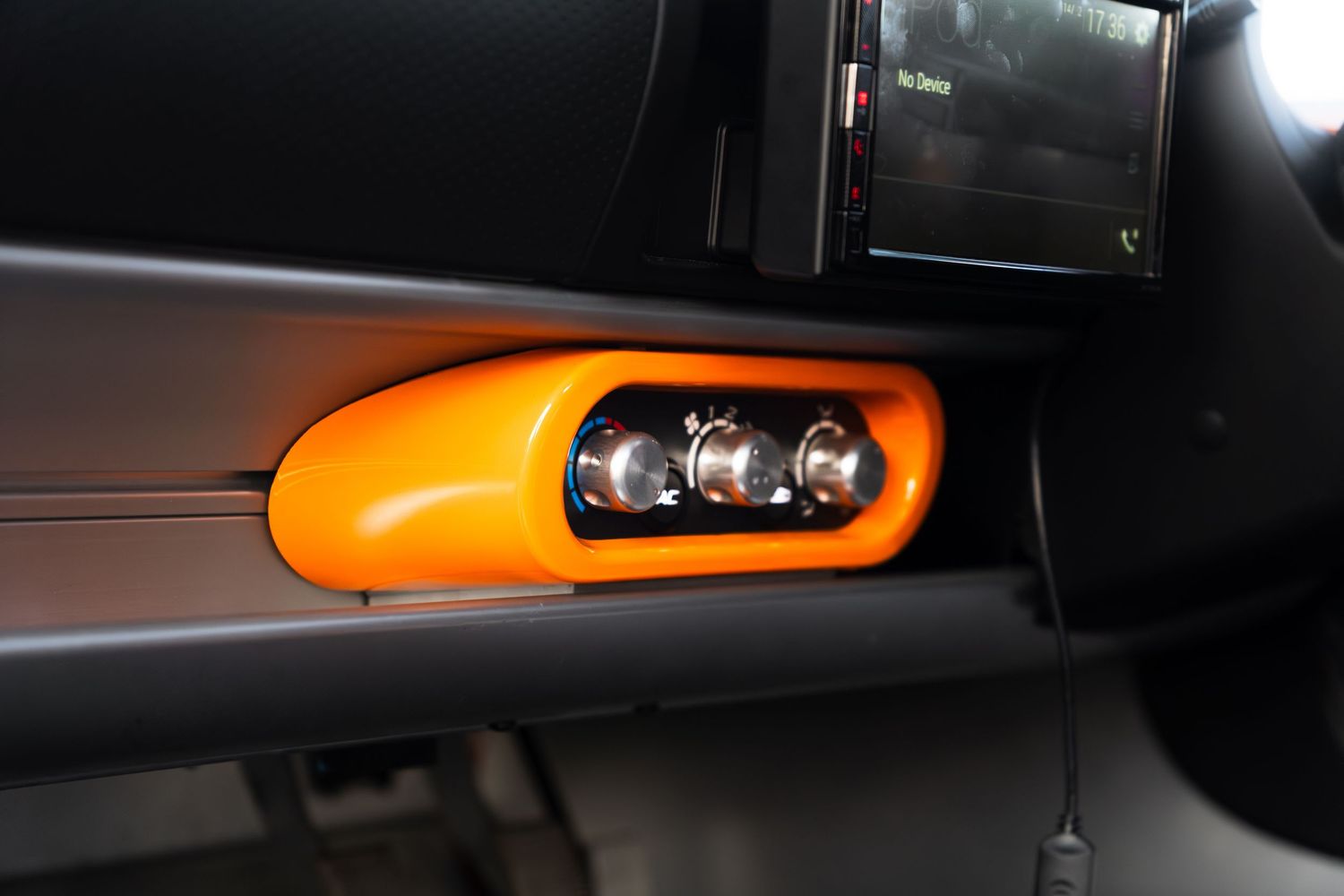 Orange Lotus Elise interior door handle and controls detail shot.