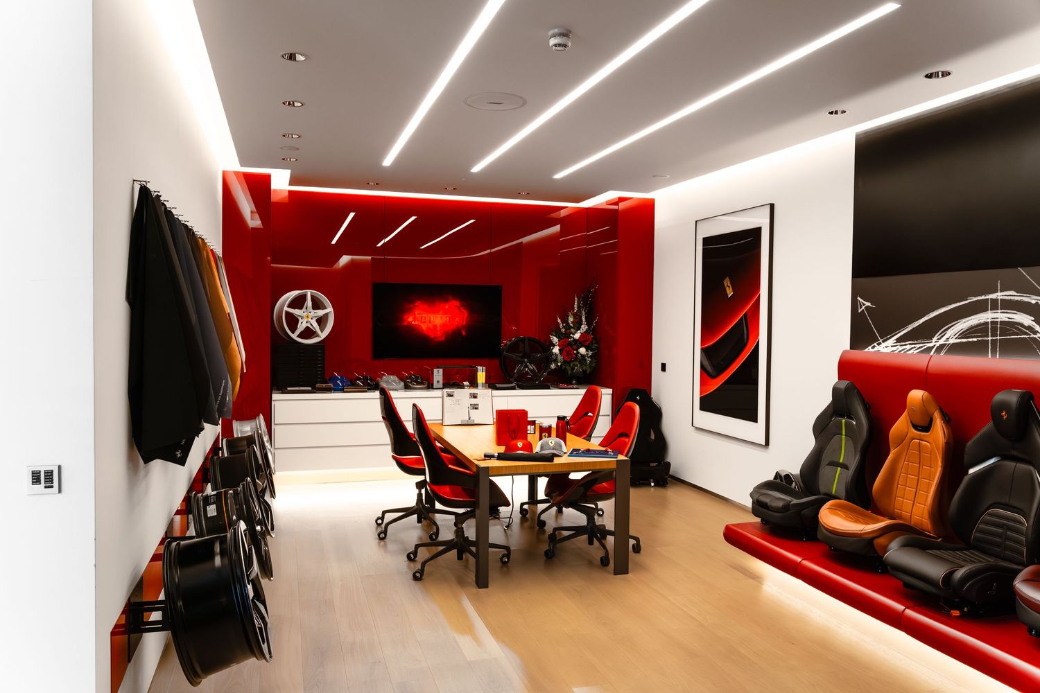 Luxurious Ferrari-themed conference room with red accents, racing seats, and branded decor elements.