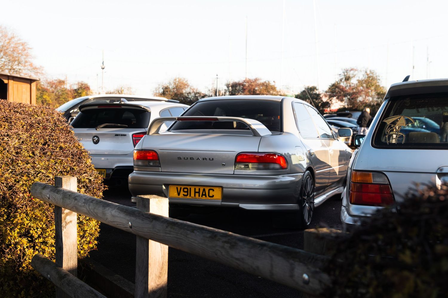 Silver Honda Integra DC2 coupe parked among other cars at an outdoor car meet.